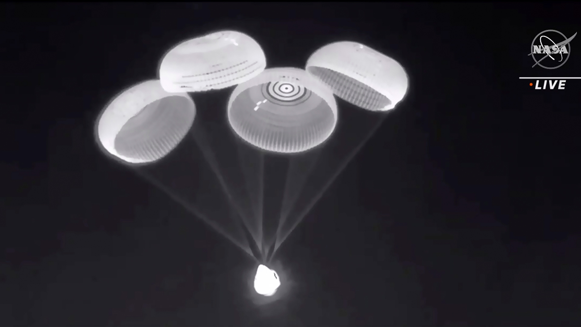 Fallschirme von der SpaceX Dragon-Kapsel mit vier Astronautinnen und Astronauten an Bord werden entfaltet. | picture alliance/dpa/NASA via AP