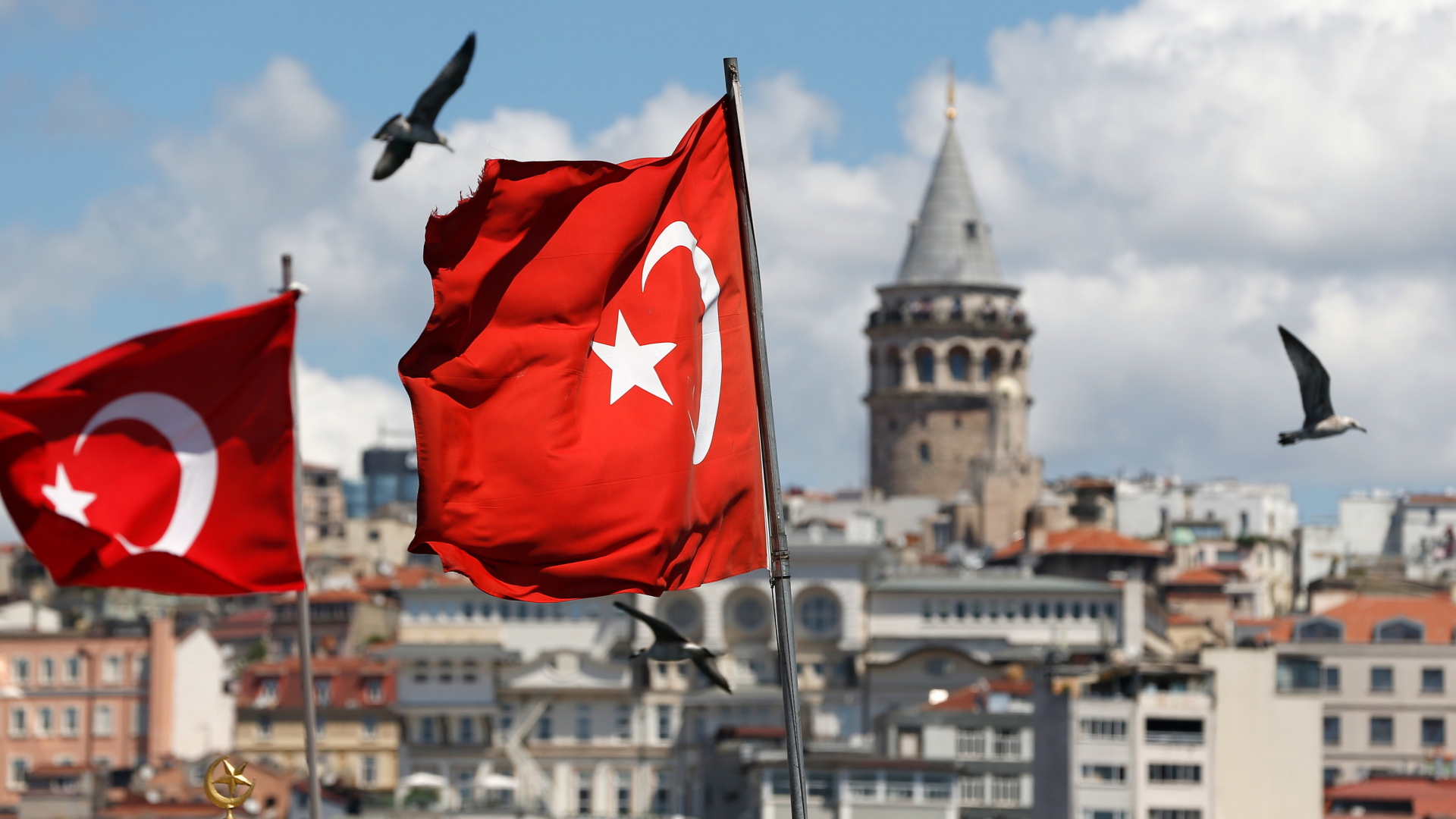 Türkische Flaggen wehen vor dem Stadtbild von Istanbul und dem Galataturm. 