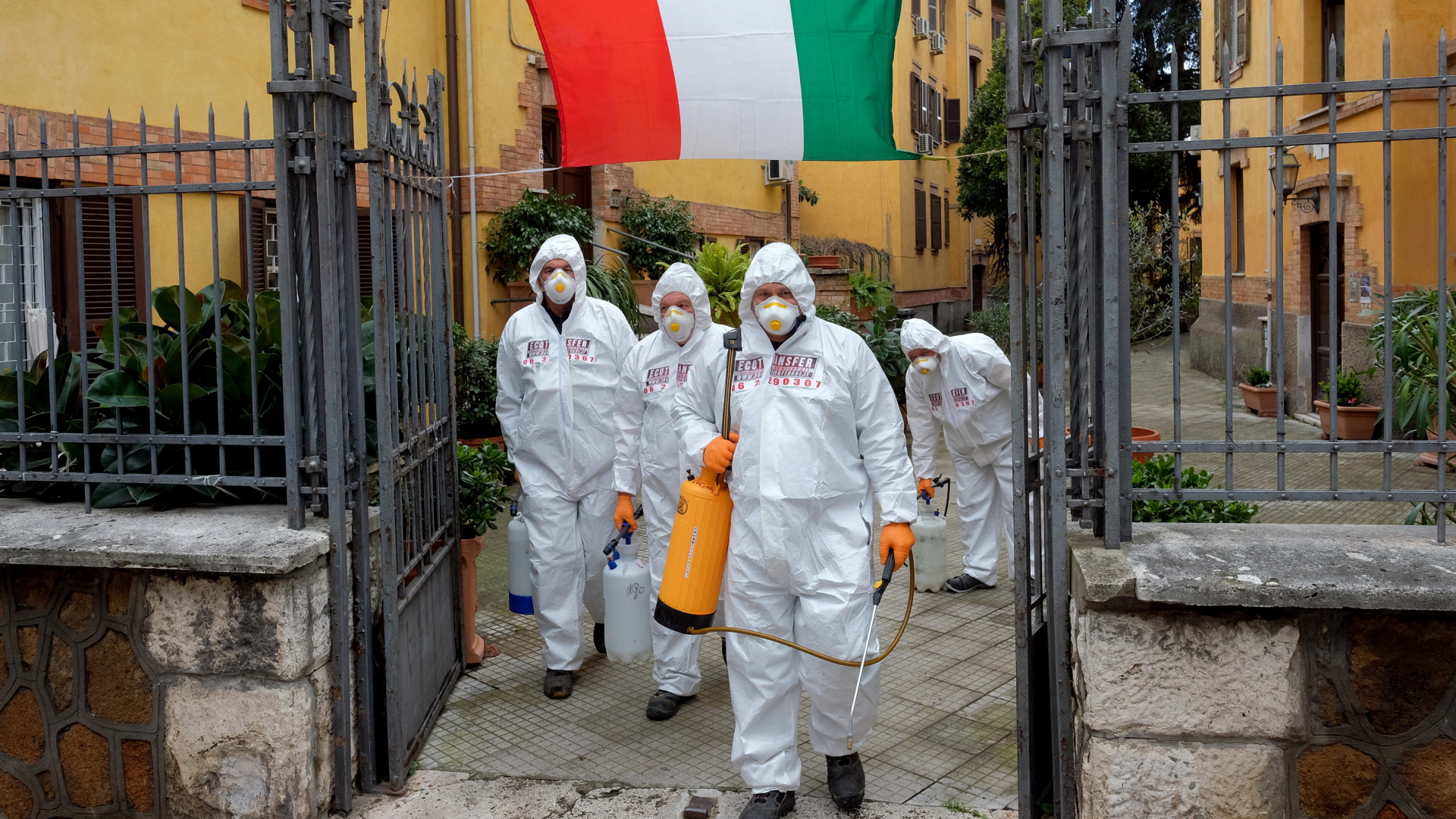 Arbeiter in Schutzkleidung desinfizieren die Gehwege in einem Viertel in Rom | Bildquelle: dpa