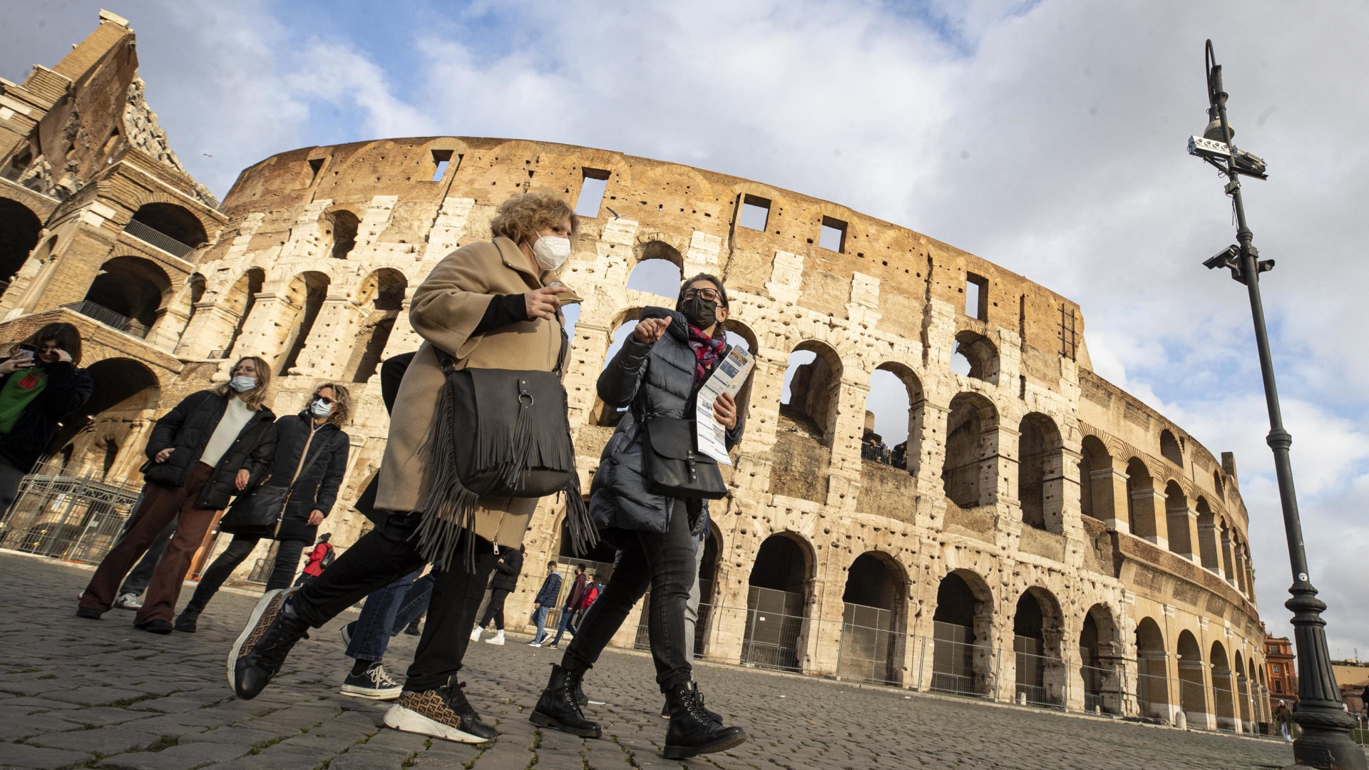 Menschen laufen mit Mund-Nasen-Schutz durch Rom | EPA