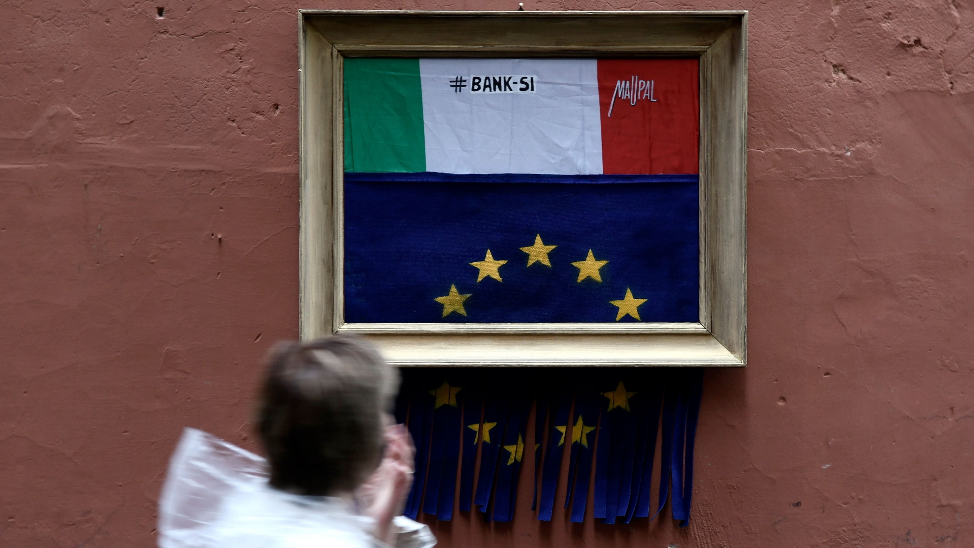 Ein Passant läuft in Rom an einer Street-Art-Installation vorbei, die auf Banksys selbstzerstörendes Bild anspielt. | AFP