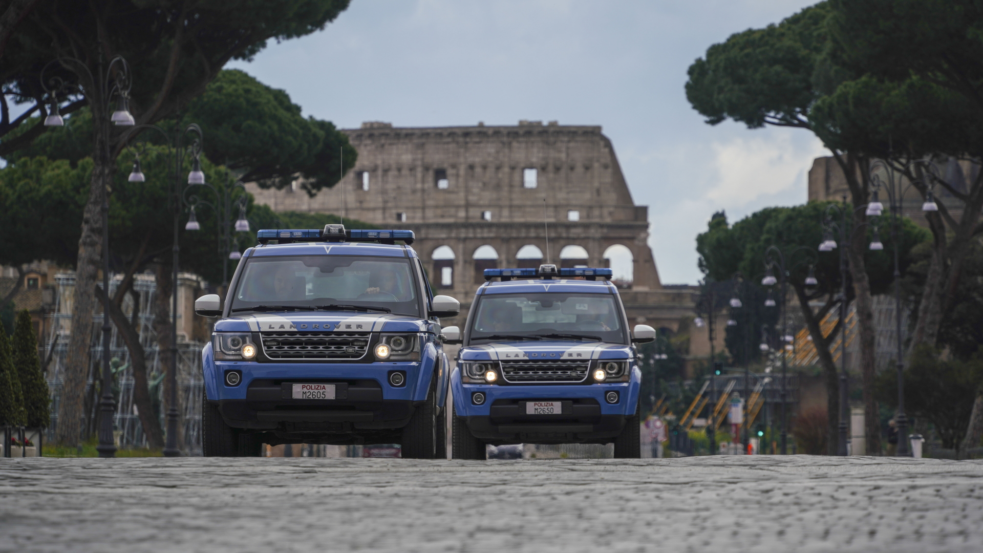 Italienische Polizeiautos patrouillieren auf einer Straße vor dem Kolosseum. (Symbolbild) | dpa