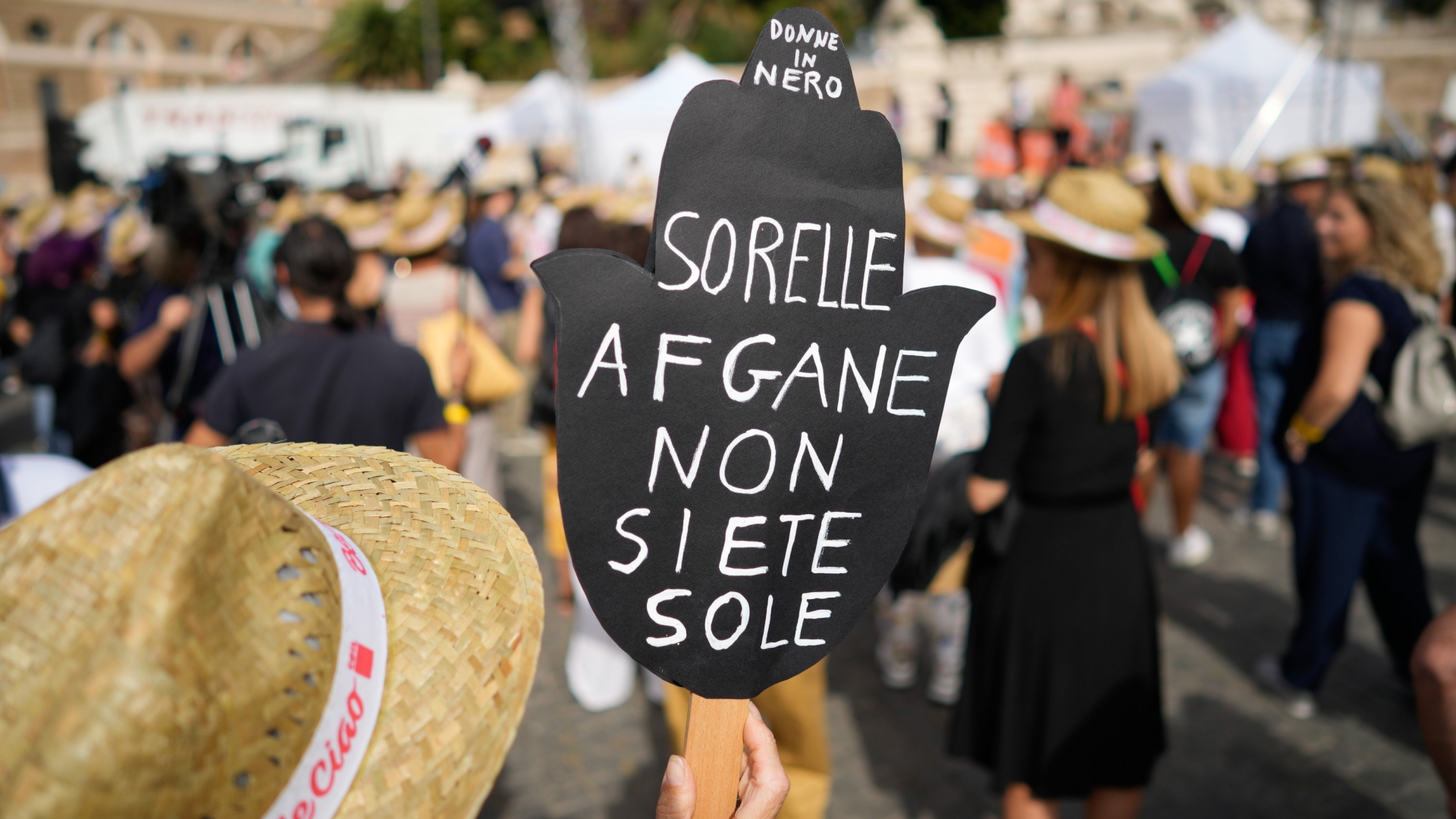 "Afghanische Schwestern, ihr seid nicht allein" steht auf einem Plakat, das eine Person auf einer Kundgebung für Afghanistan in Rom hochhält (Bild vom 25.09.2021). | AP