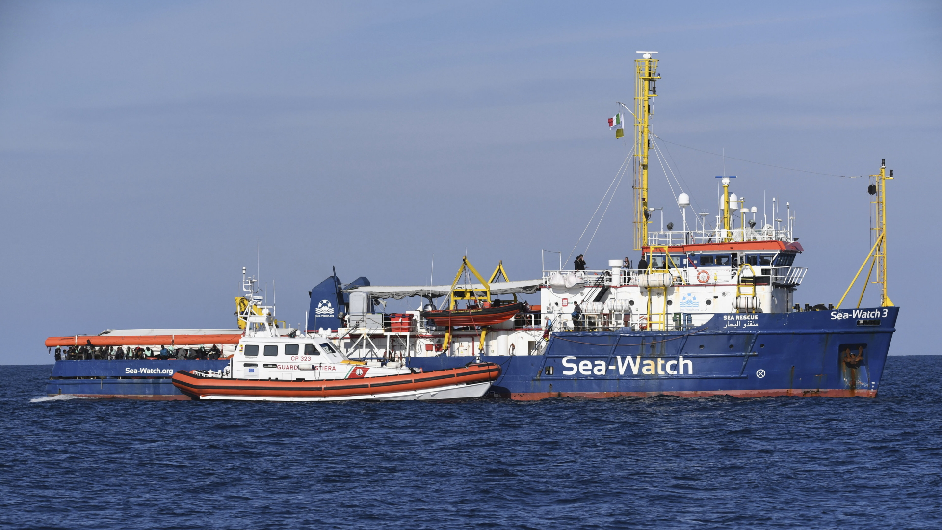 Ein Schiff der italienischen Küstenwache nähert sich dem Rettungsschiff "Sea Watch 3" der deutschen Hilfsorganisation "Sea Watch" vor der Küste Siziliens. | dpa