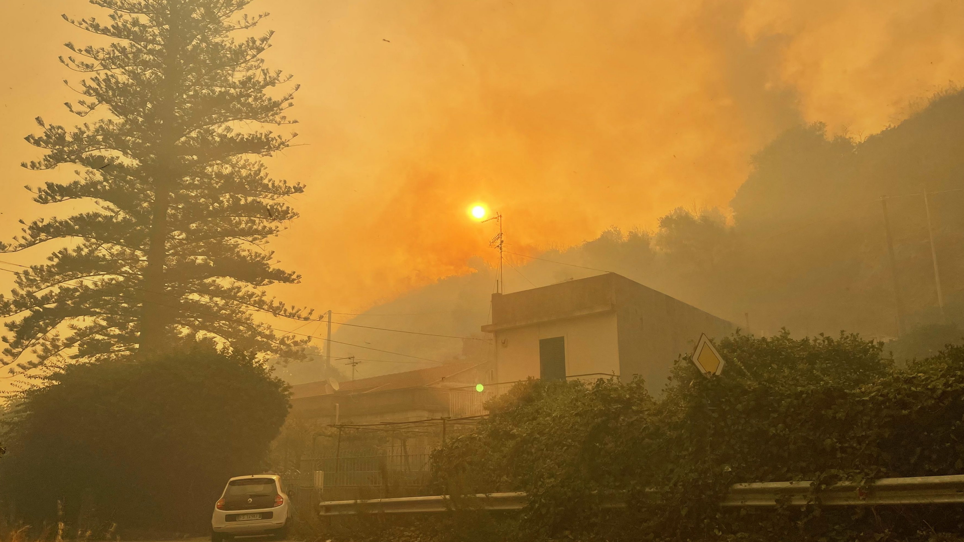 Durch Brände überzieht dicker Rauch den gelblich scheinenden Himmel über Sizilien.