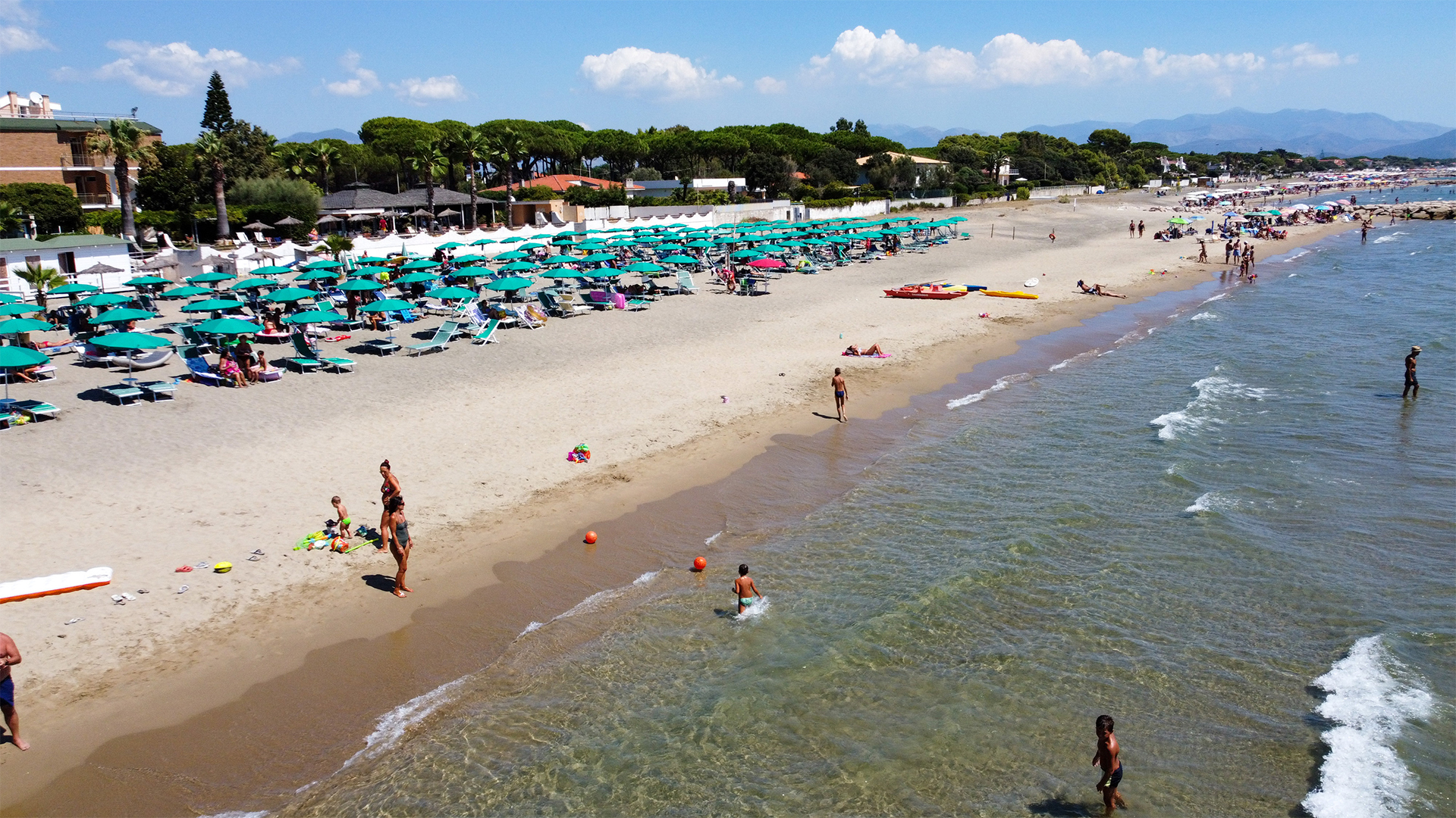Einige Besucher baden im Meer am Strand von Terracina.  | dpa