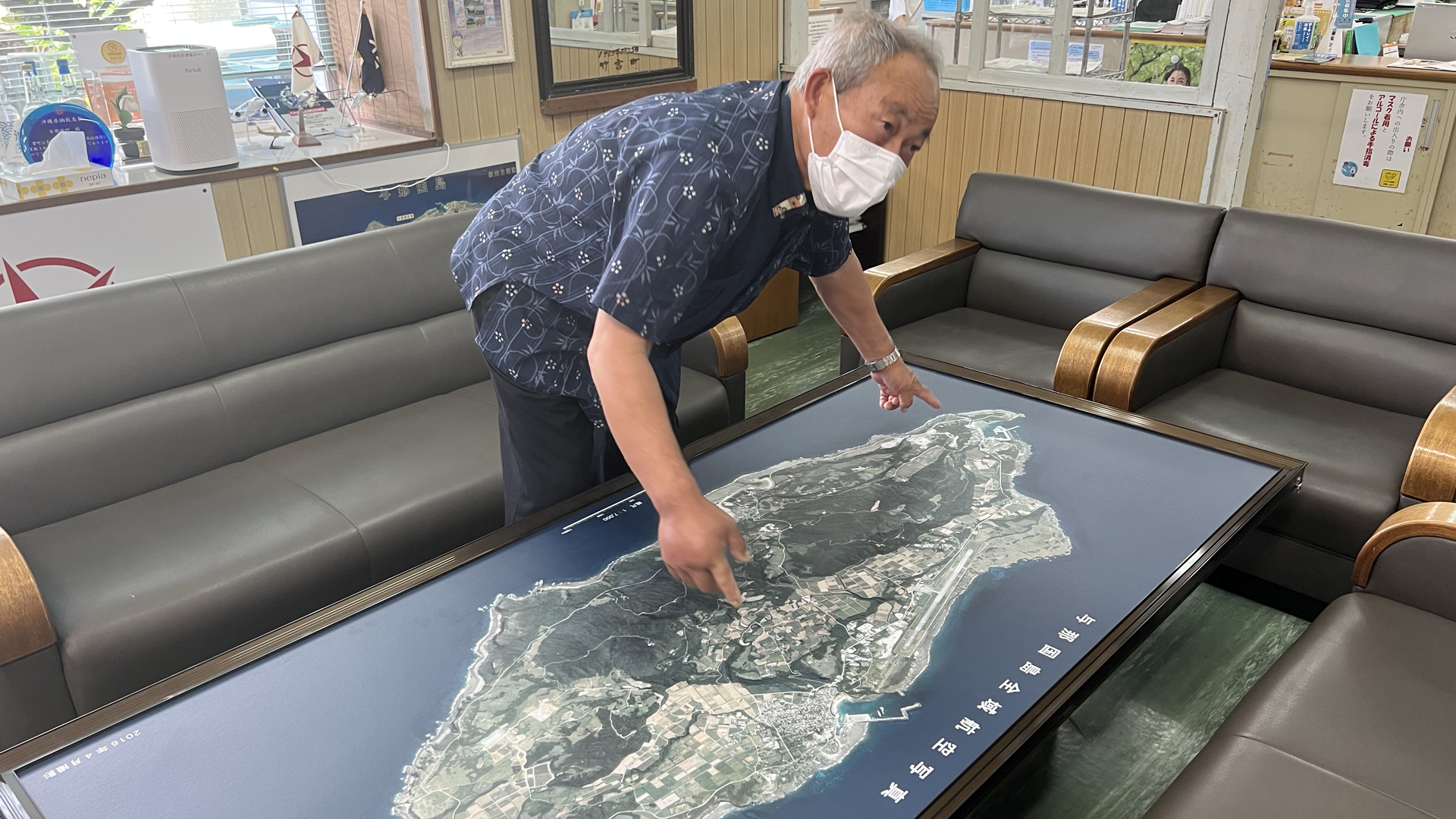 Insel-Bürgermeister Kenichi Itokazu vor einer Insel-Landkarte | ARD-Studio Tokio