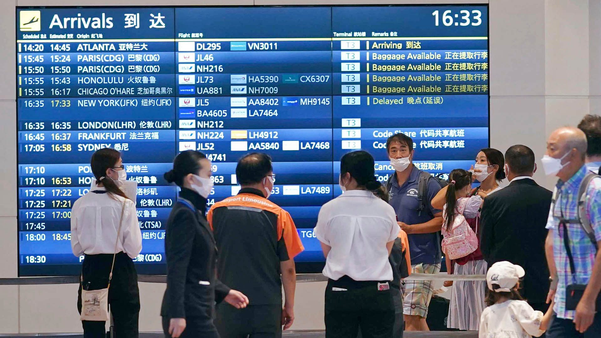 Menschen in der Ankunftshalle des Flughafens Haneda in Tokio. | AP