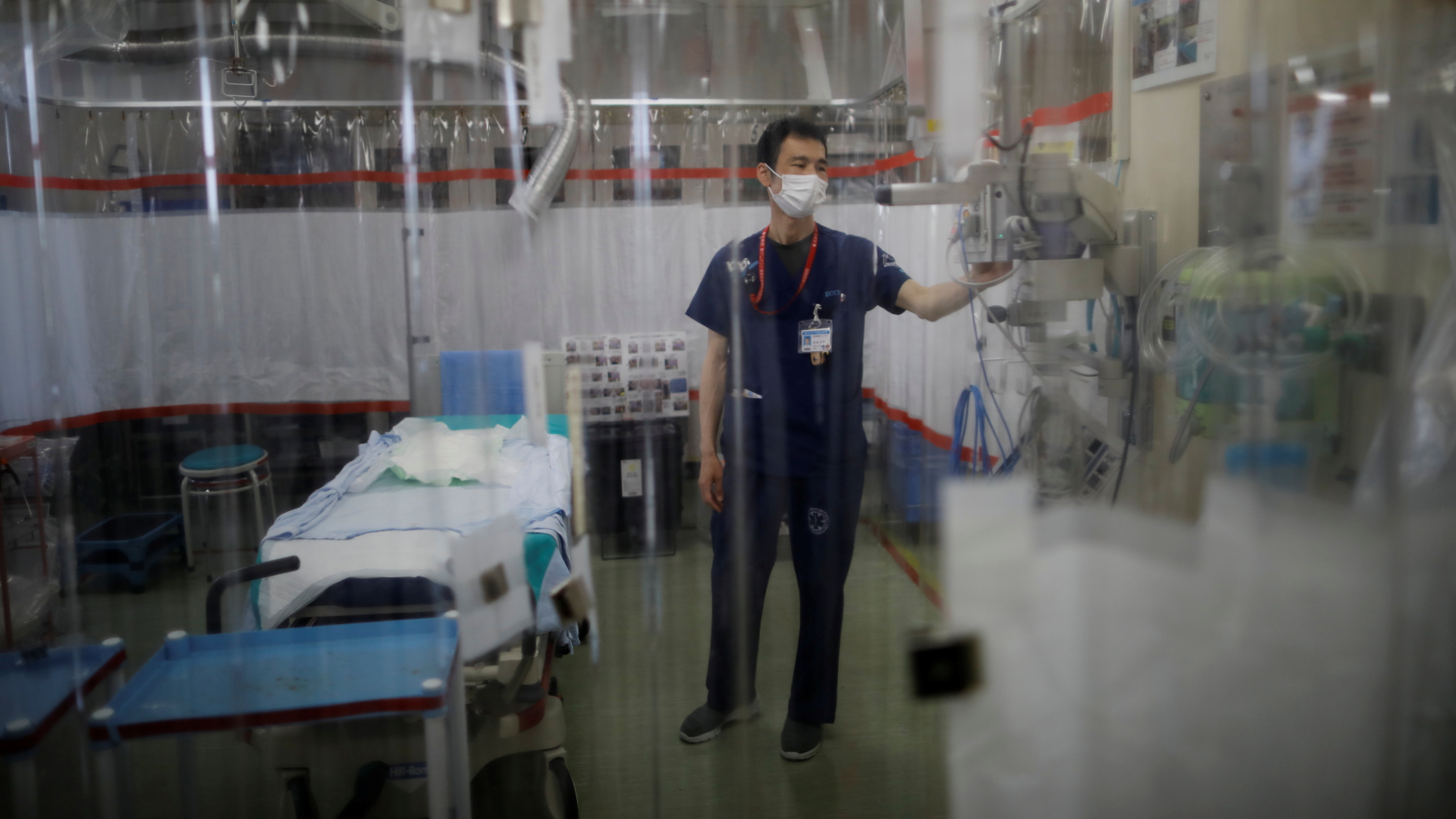 Ein Mitarbeiter der Universitätsklinik in Yokohama hinter Plastikvorhängen. | REUTERS