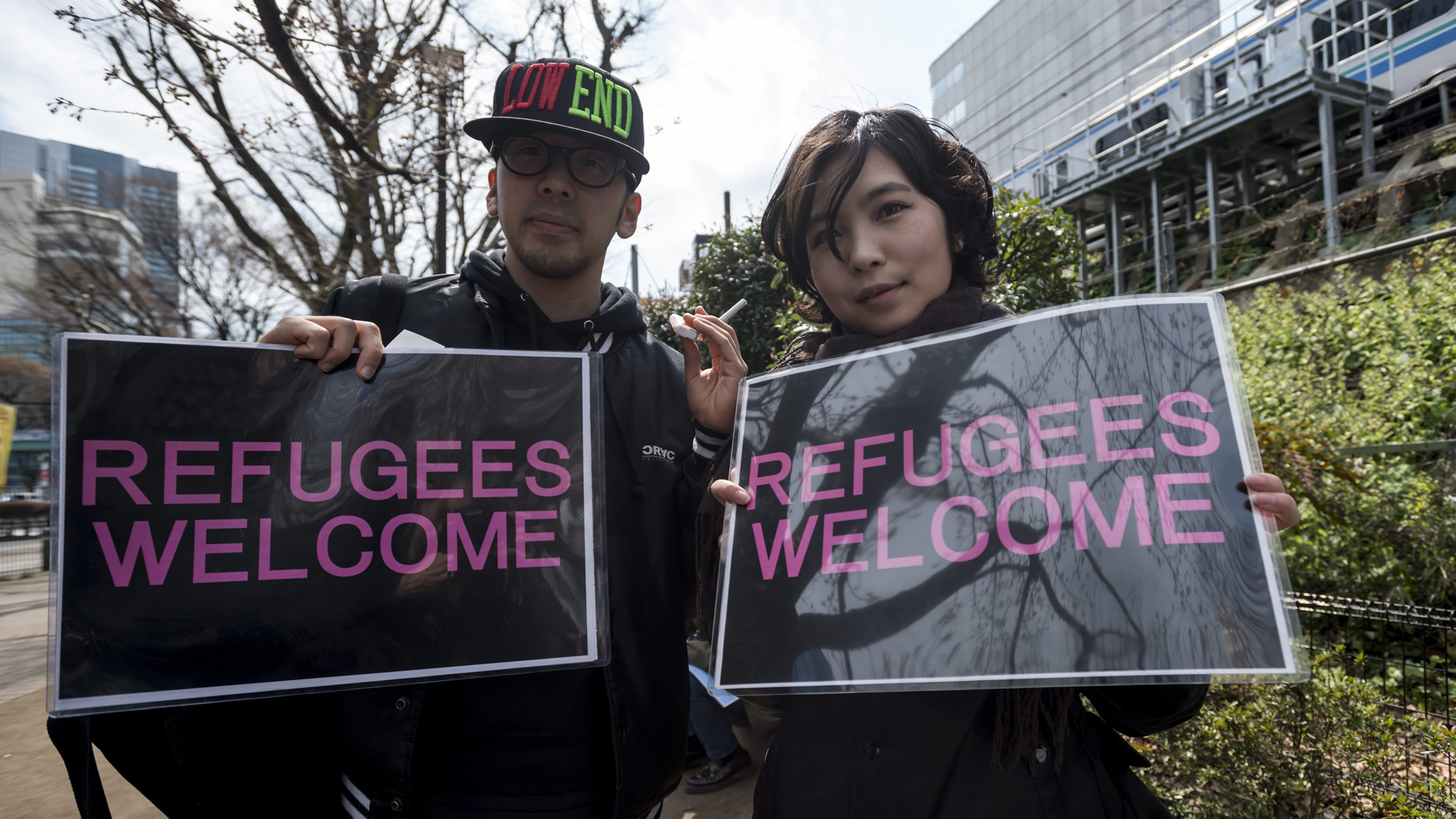 "Flüchtlinge willkommen" steht auf den Protestschildern zweier Demonstrationsteilnehmer. | picture alliance / NurPhoto