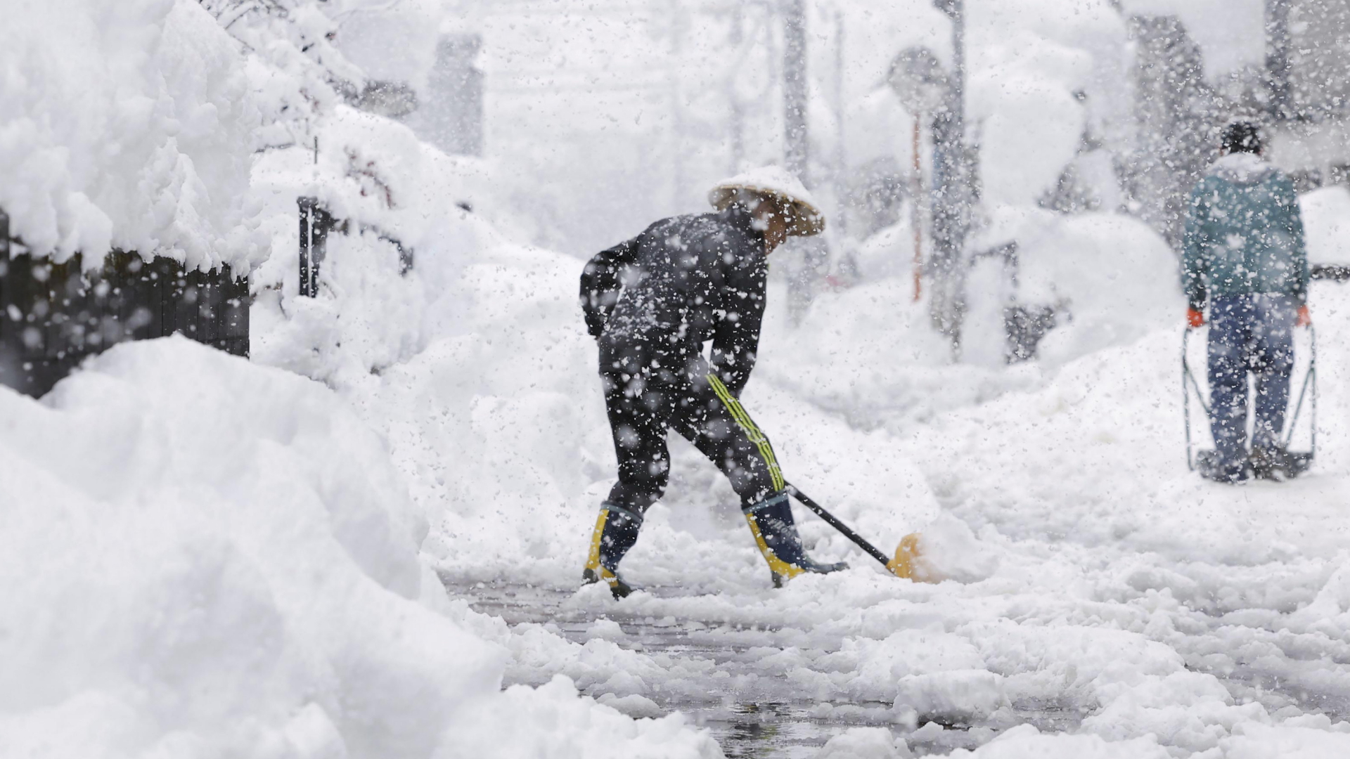 Ein Mann räumt bei anhaltendem Schneefall in Nagaoka im Norden Japans einen Fußweg. | AP