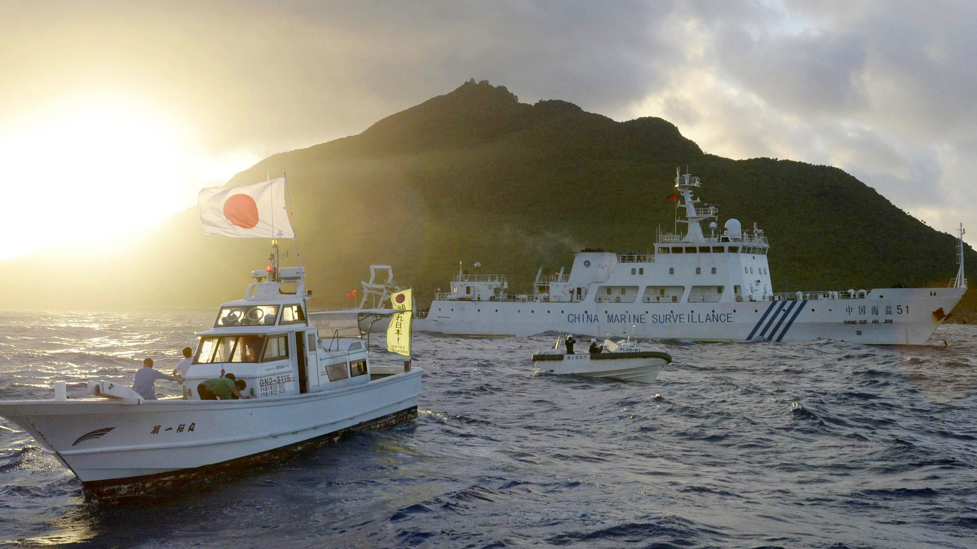Ein chinesisches Patrouillenboot kreuzt nahe einem Boot mit japanischer Flagge vor einer der Senkaku-Inseln. | picture alliance/dpa/MAXPPP