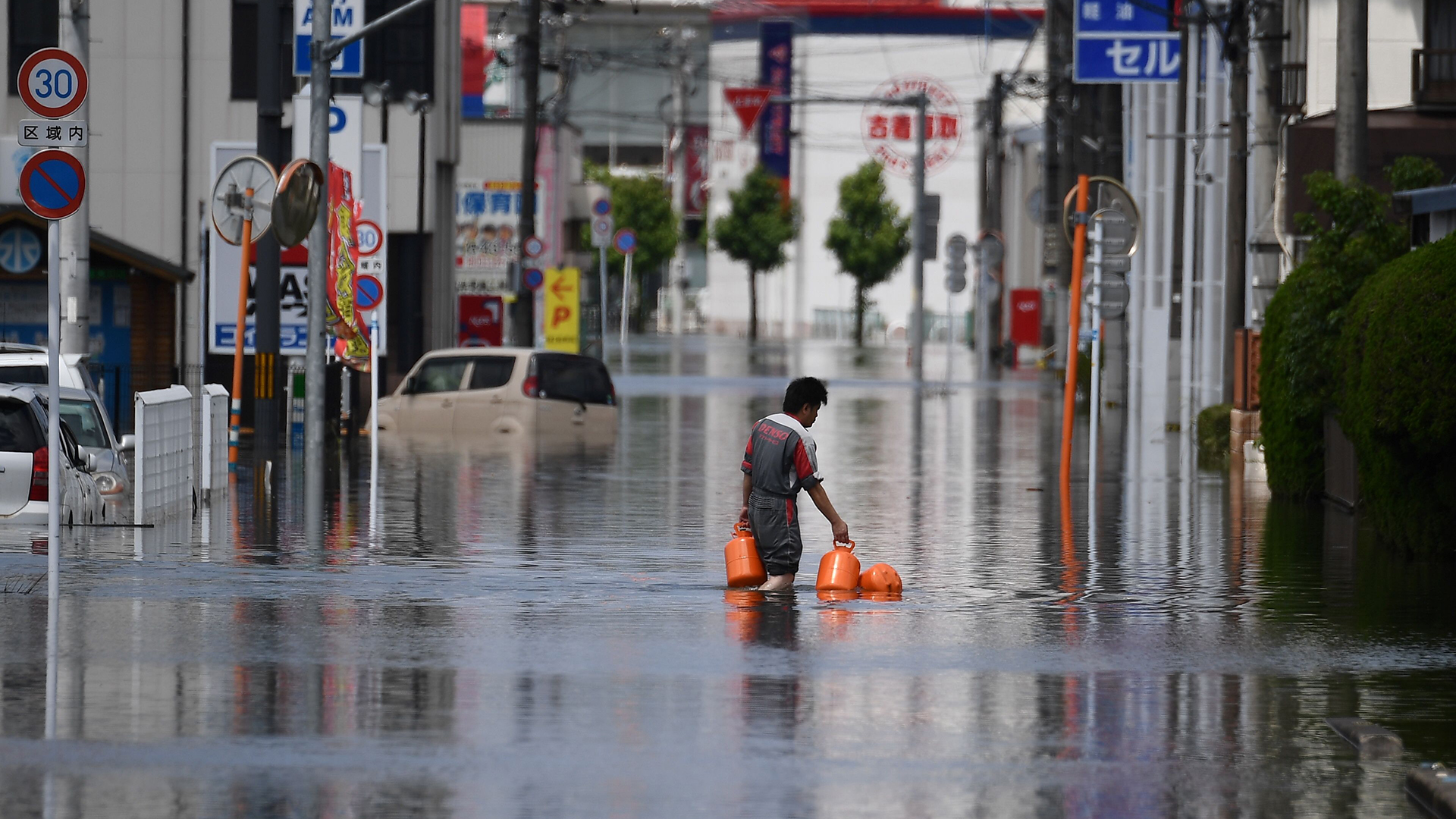Ein Mann geht über eine überschwemmte Straße | AFP