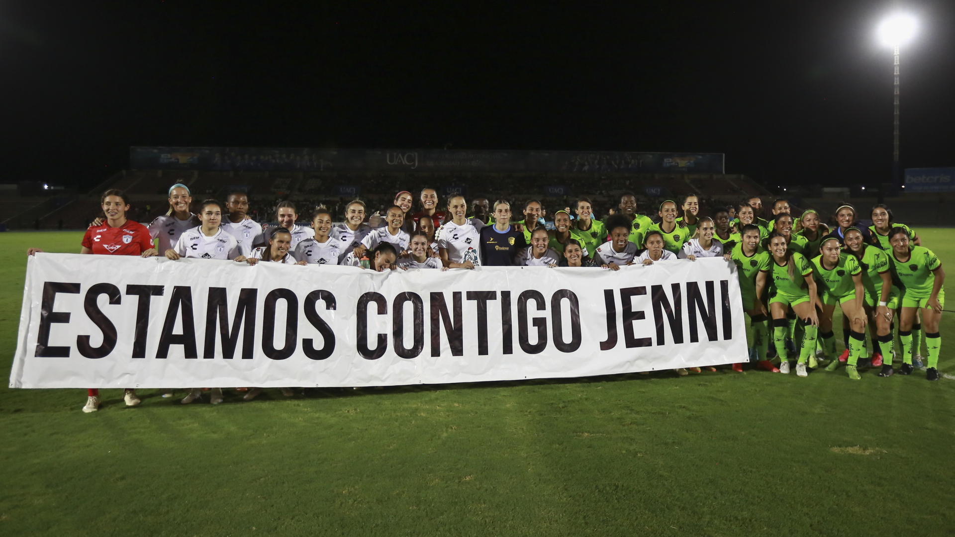 Spielerinnen des Frauenfußballvereins Pachuca halten vor Beginn eines Spiels ein Transparent mit der spanischen Aufschrift «Wir sind mit dir Jenni» hoch, die sich auf ihr Mannschaftsmitglied Jenni Hermoso bezieht.