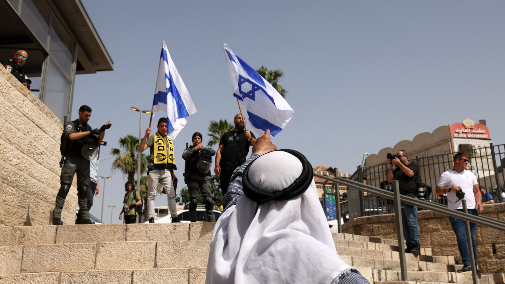 Ein Palästinenser gestikuliert in Richtung von Menschen mit israelischen Flaggen. | AFP