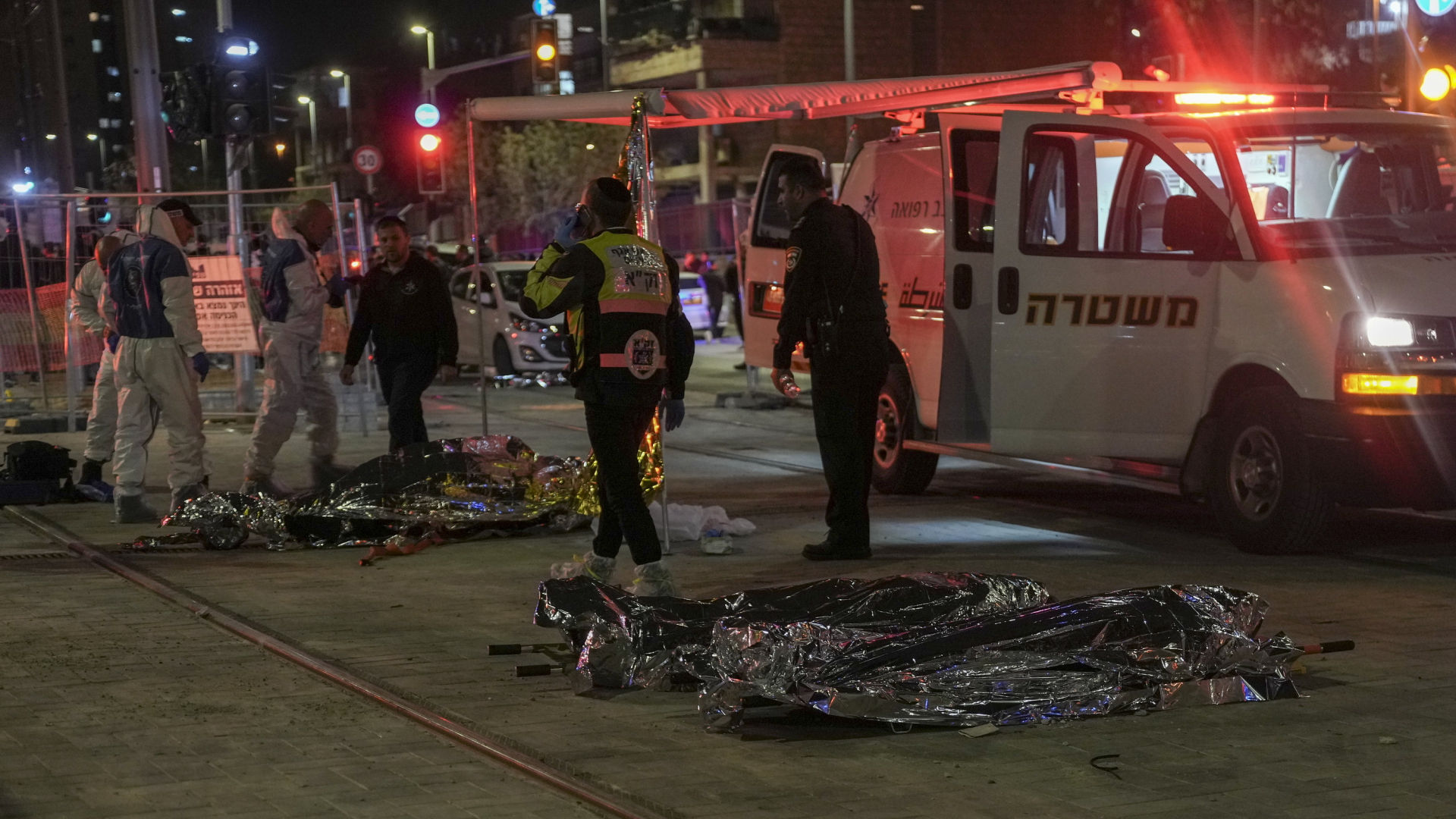 Rettungseinsatz nach Angriff mit mehreren Toten in Jerusalem. Mehrere abgedeckte Opfer liegen auf dem Boden.