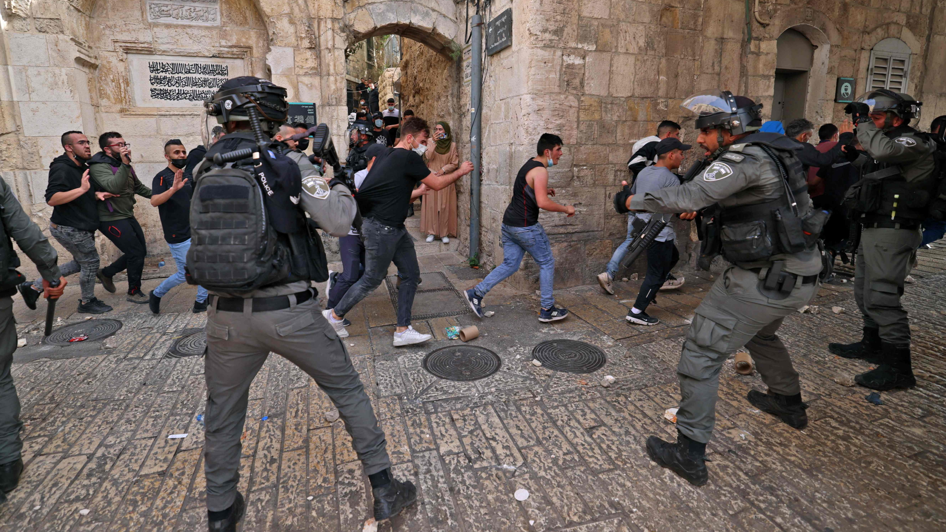 Israelische Polizisten fordern flüchtende Palästinenser auf, sich aus der Altstadt, wo es zu schweren Zusammenstößen kommt, zurückzuziehen. | AFP