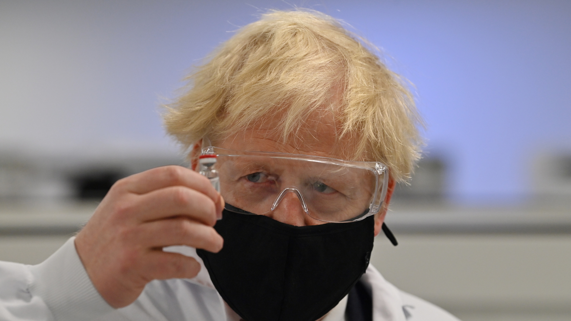 Boris Johnson, Premierminister von Großbritannien, hält ein Fläschchen eines potenziellen Corona-Impfstoffs. | dpa