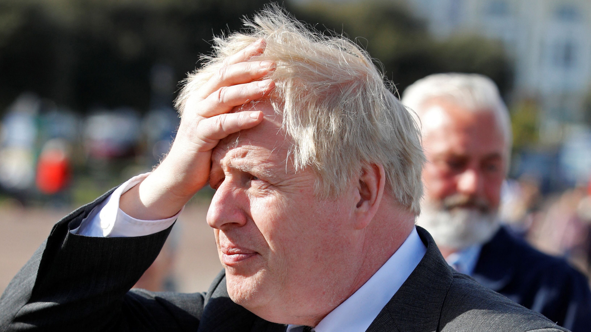 Boris Johnson fasst sich während eines Wahlkampfauftritts an den Kopf | AFP