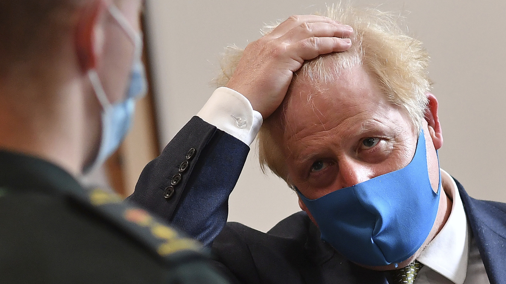 Großbritanniens Premier Boris Johnson trägt im Gespräch mit Mitarbeitern des London Ambulance Service einen Mund-Nasen-Schutz. | AP
