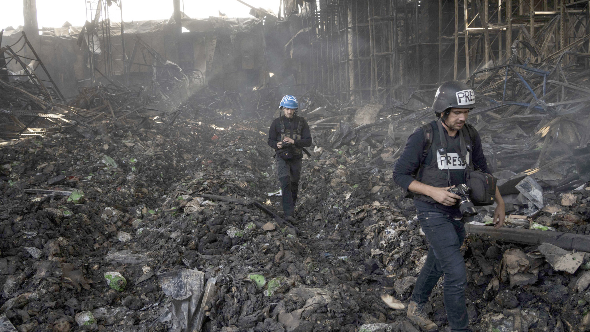 Journalisten laufen durch ein zerstörtes Einkaufszentrum in Kiew | AP