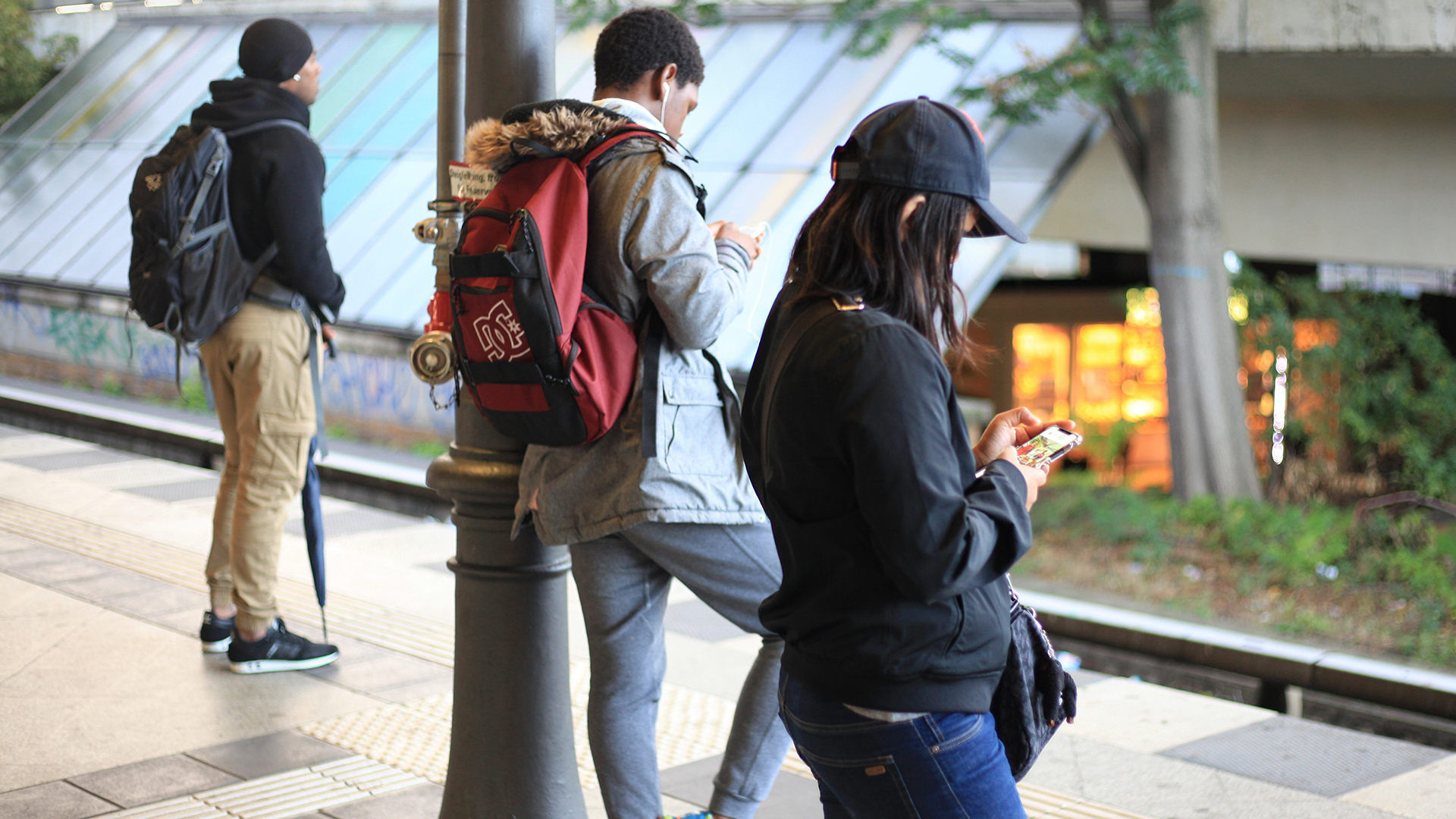 Jugendliche schauen in Berlin auf einem Gleis einer S-Bahnstation auf ihre Smartphones. | picture alliance / Wolfram Stein