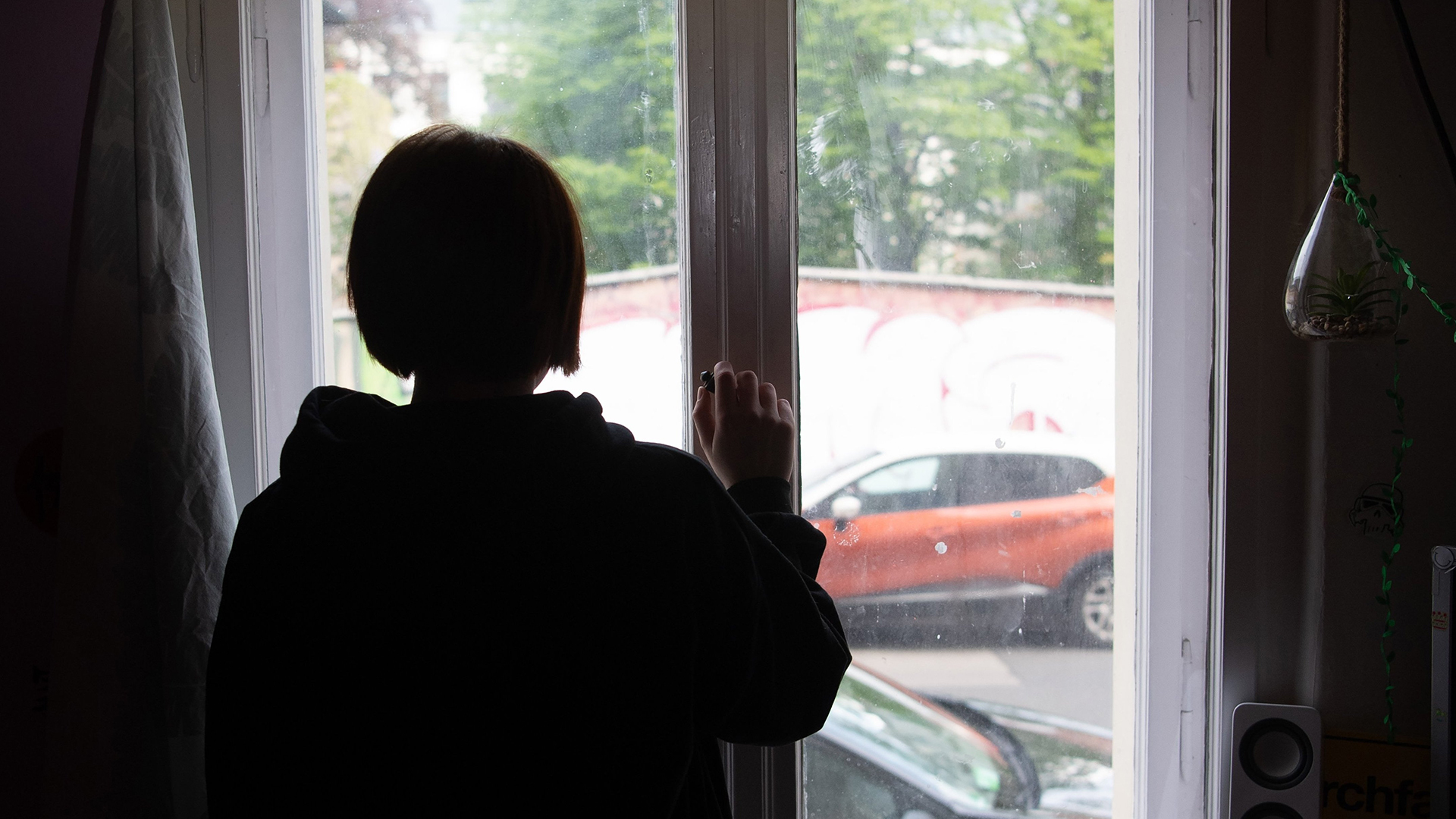 Eine Jugendliche blickt aus einem Fenster. | dpa
