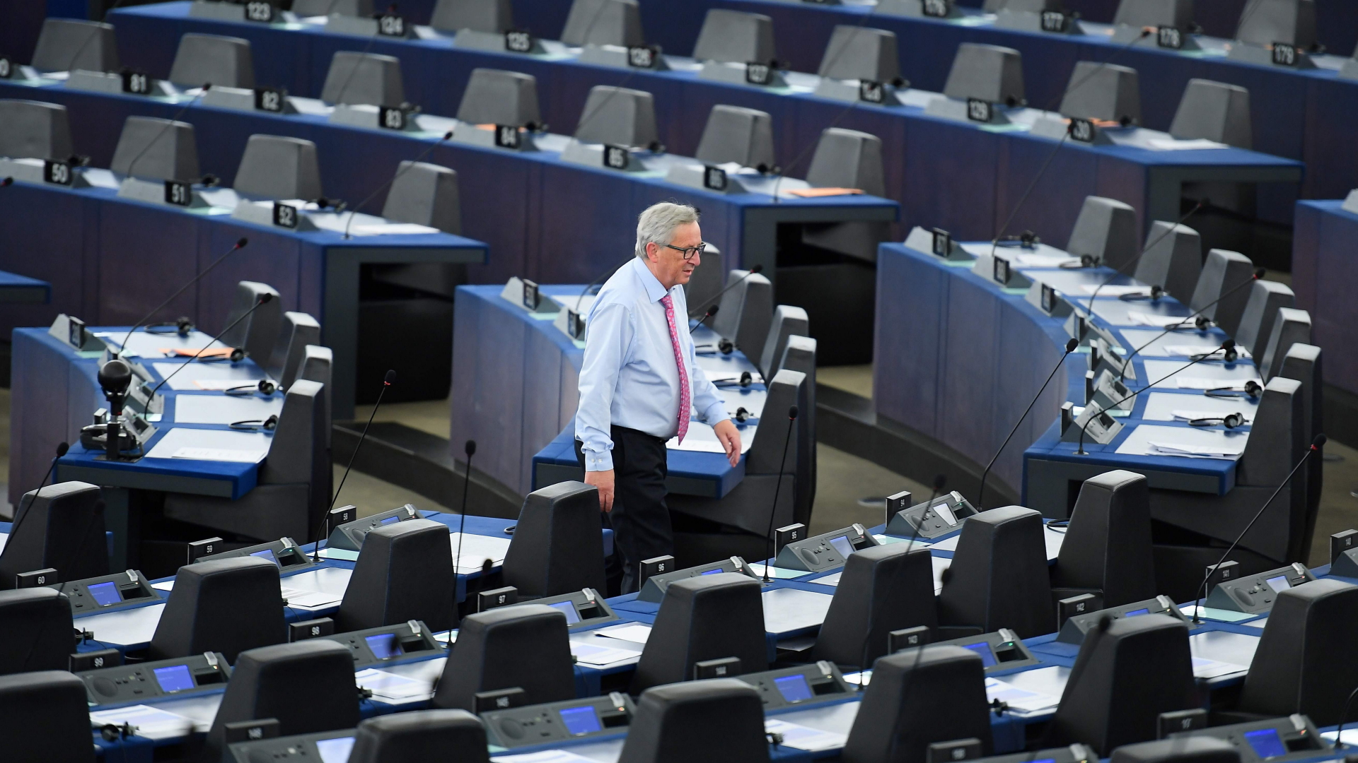 EU-Kommissionspräsident Juncker geht durch die leeren Ränge des EU-Parlaments. | AFP
