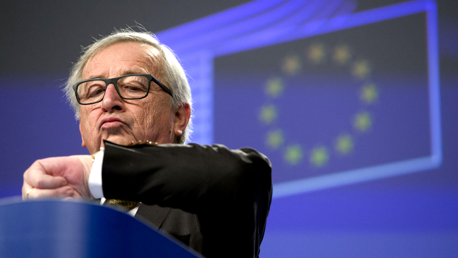 Jean-Claude Juncker schaut auf seine Armbanduhr. | dpa