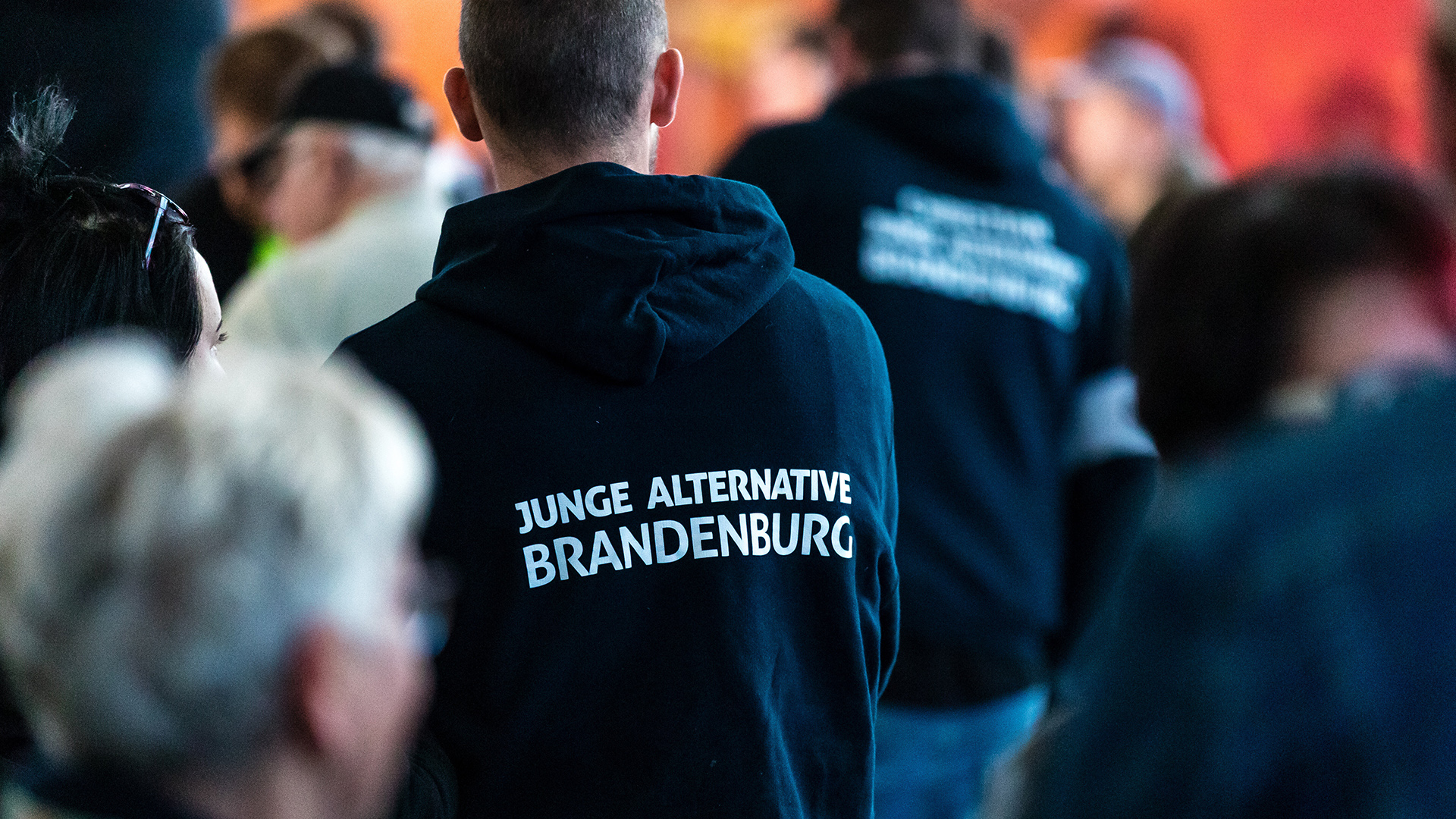 Teilnehmer einer Wahlkampfveranstaltung tragen Kleidung mit der Aufschrift "Junge Alternative Brandenburg".