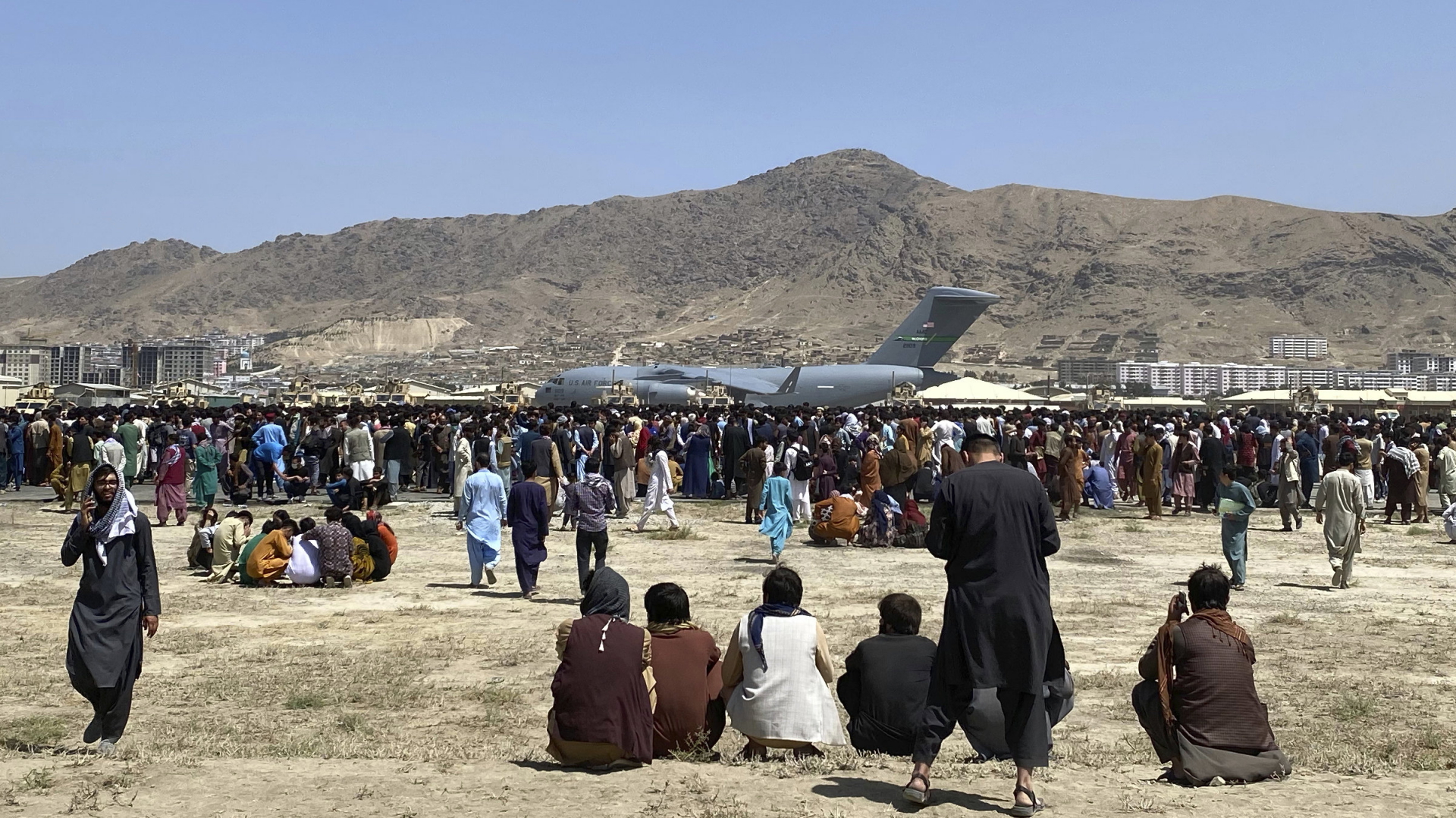 Zahlreiche Menschen versammeln sich in der Nähe eines US-amerikanischen Militärflugzeugs auf dem Gelände des Kabuler Flughafens.