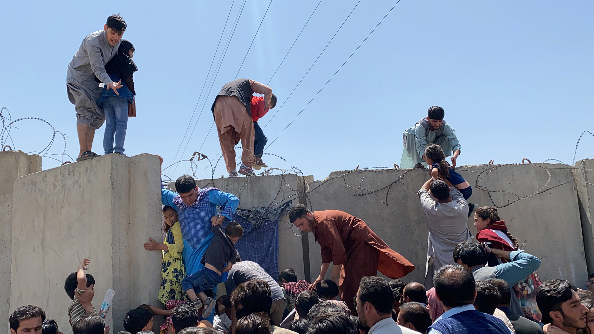 Menschen versuchen über die Mauer auf den Flughafen in Kabul zu gelangen. | EPA
