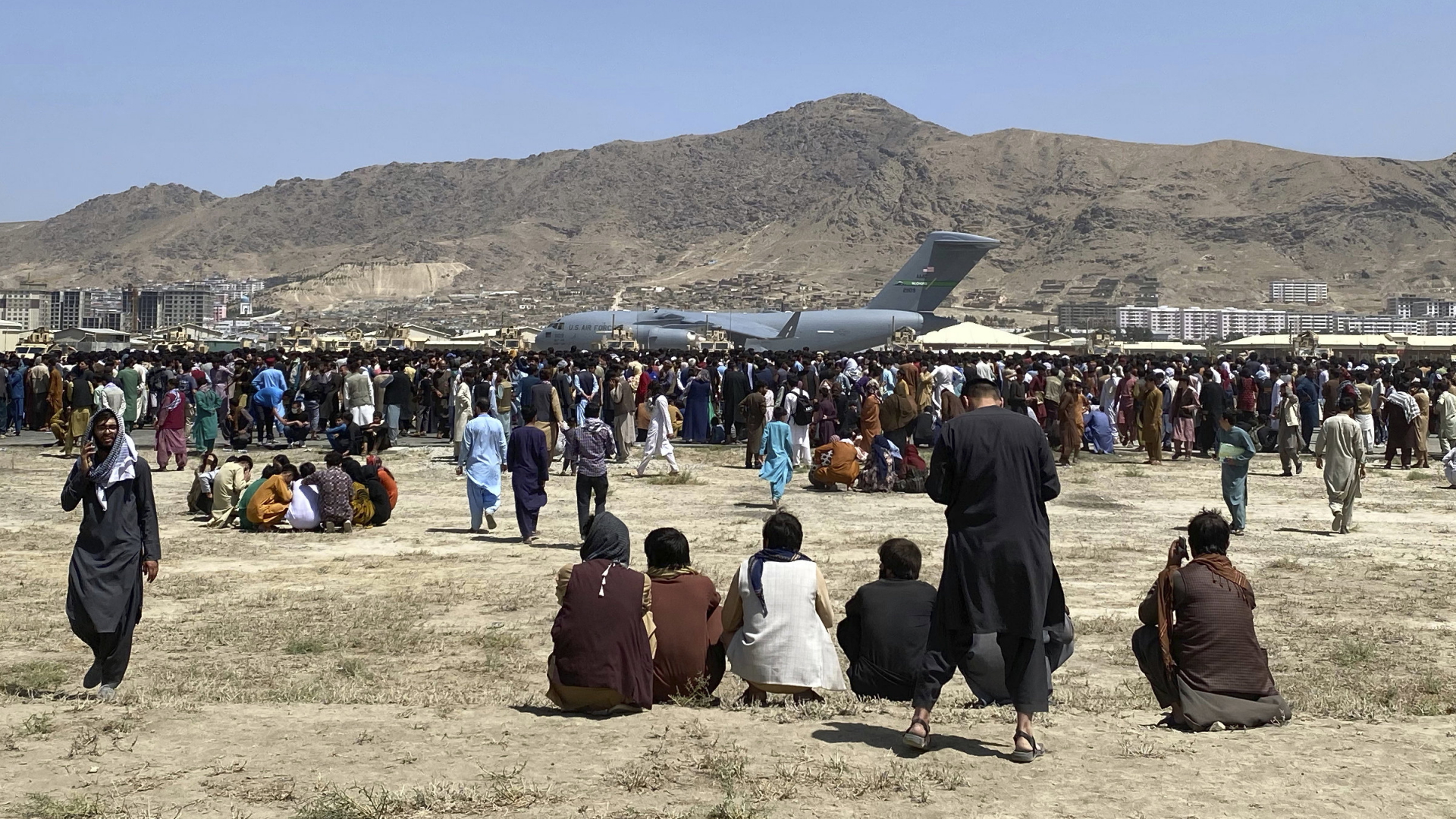Hunderte Menschen warten vor einer US-Militärmaschine am Flughafen in Kabul, Afghanistan. | AP