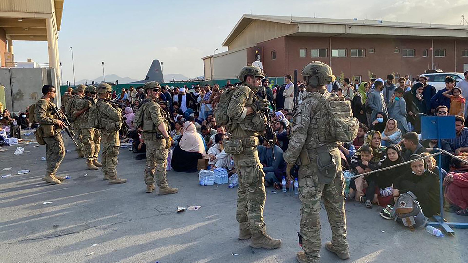 US-Soldaten stehen auf dem Militärflughafen in Kabul Wache, während afghanische Bürger darauf warten, ein US-Militärflugzeug zu besteigen.