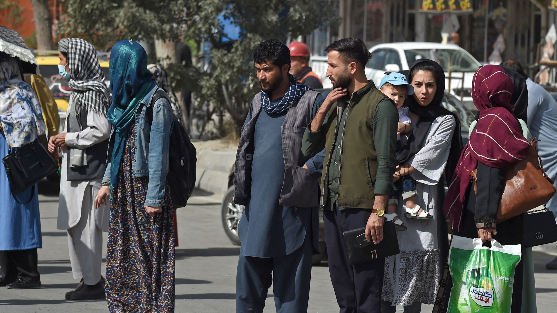 Einwohner Kabuls stehen an einer Straße | AFP