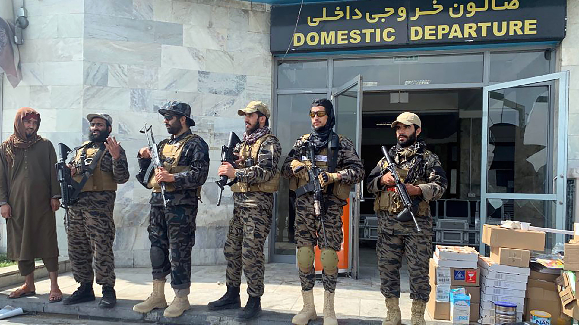 Bewaffnete Kämpfer der Taliban stehen vor der Abflughalle am Flughafen von Kabul. | AP
