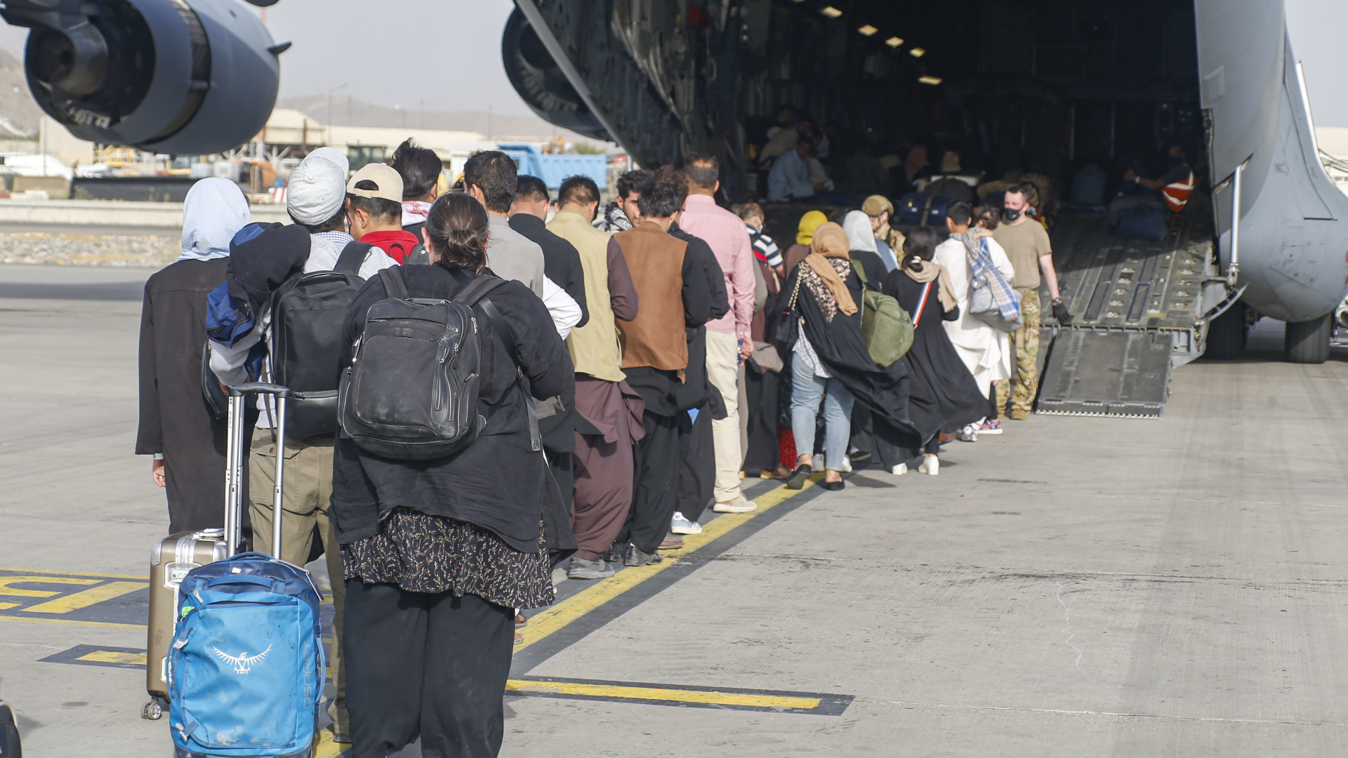 Dieses von der US-Armee verbreitete Foto zeigt Menschen auf dem Flughafen von Kabul, die vor der Rampe einer C-17-Frachtmaschine warten. | dpa