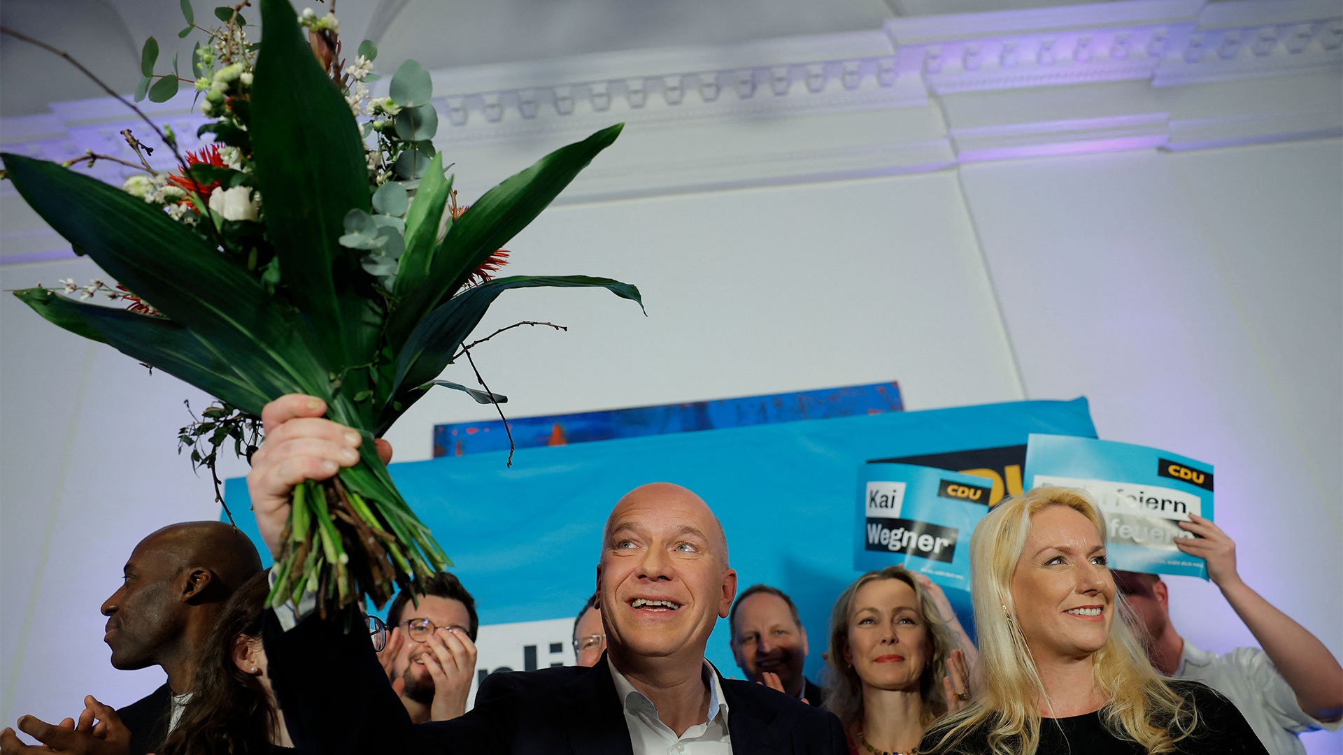 Kai Wegner hält einen Blumenstrauß  bei der Wahlparty der CDU in Berlin. | AFP