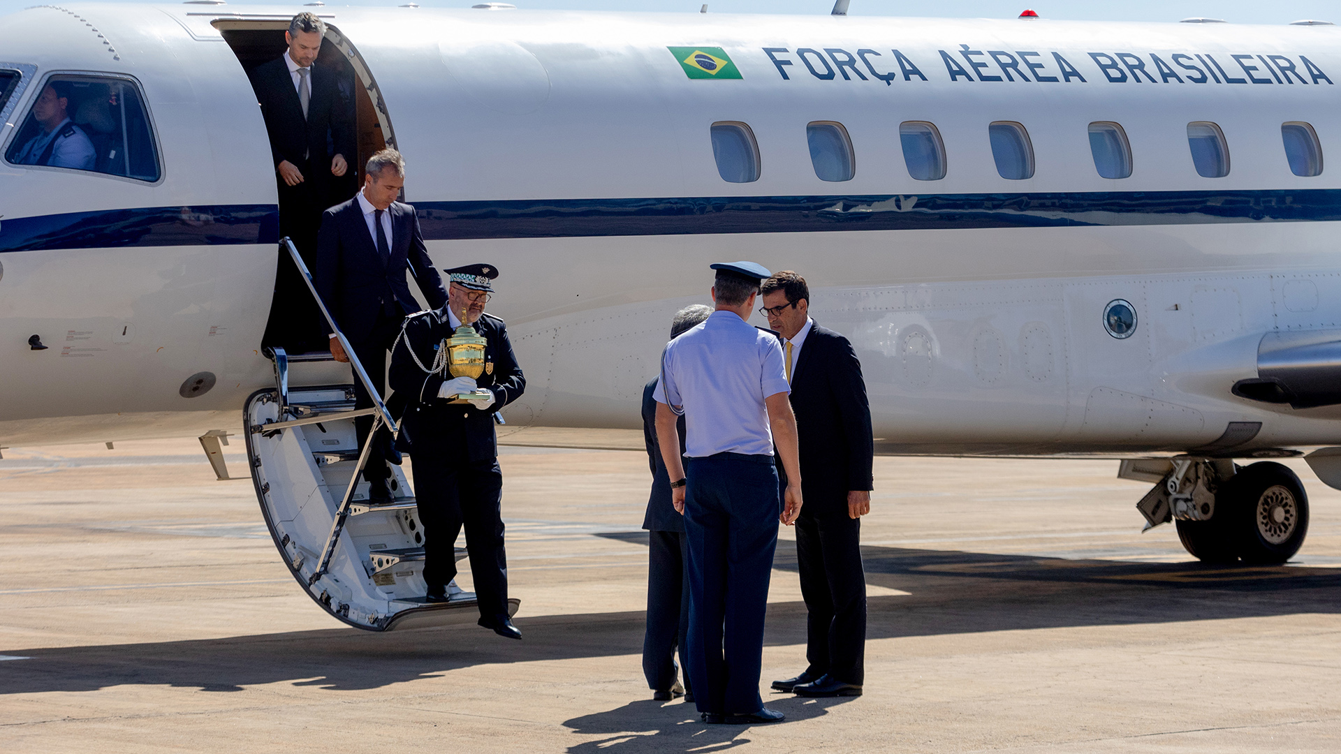 Eine goldene Urne wird aus einem Personenflugzeug der Brasilianischen Luftwaffe getragen. | dpa