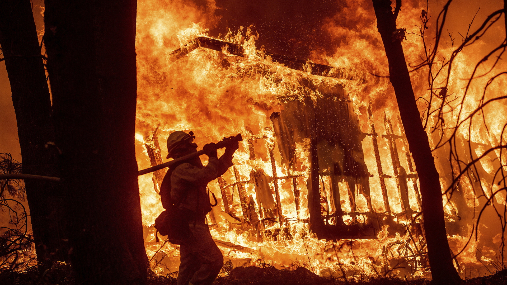 Ein Feuerwehrmann kämpft gegen die Flammen. | Bildquelle: AP