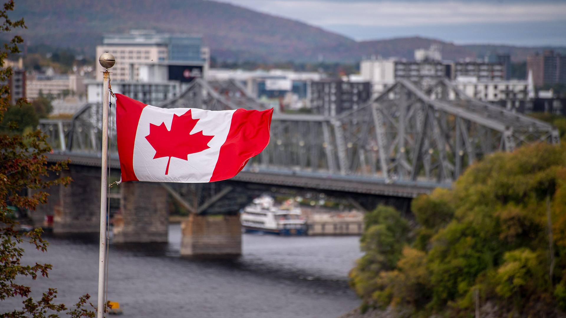 Eine kanadische Fahne flattert vor der Alexandra Bridge in Ottawa.