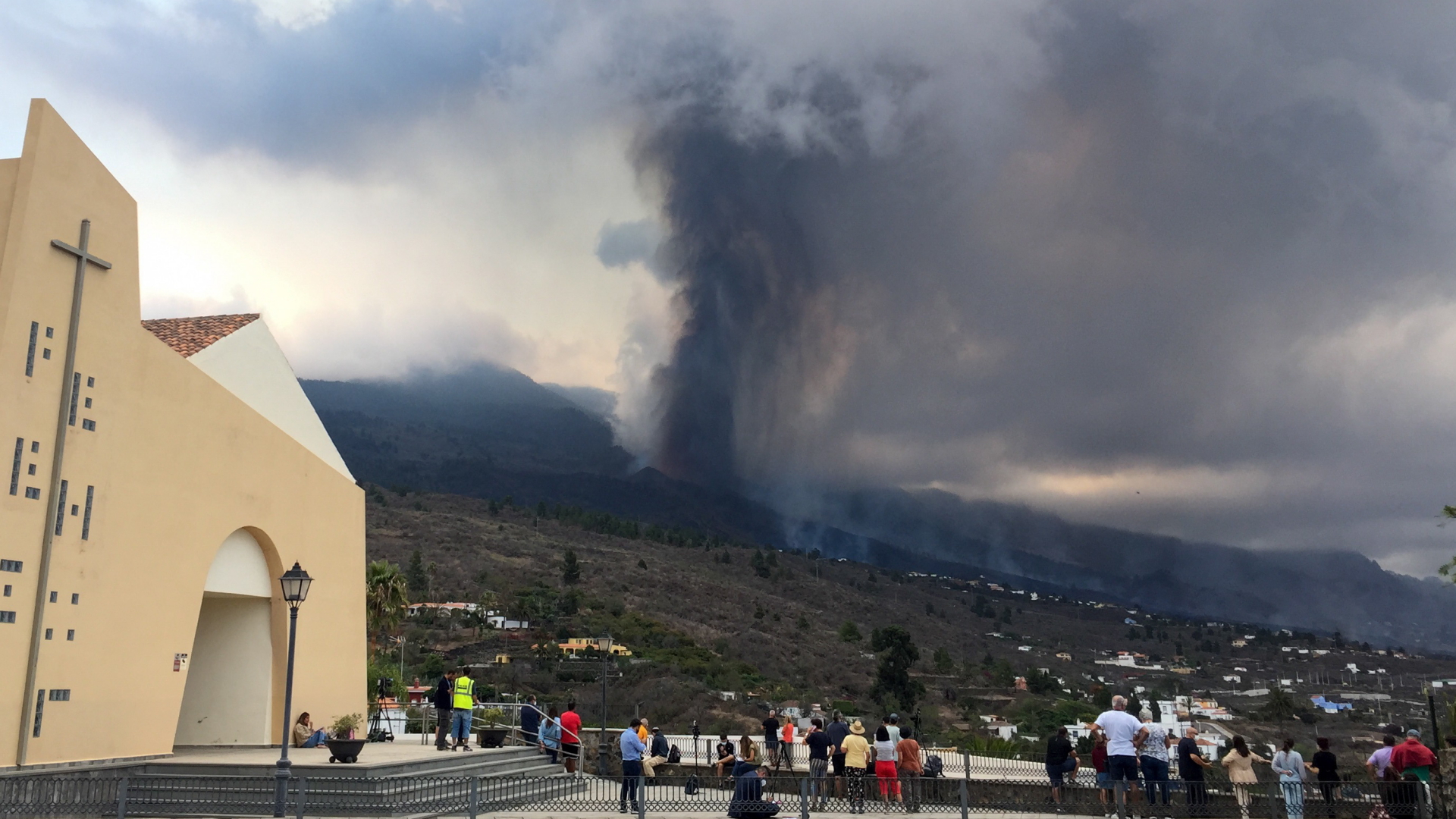 Menschen beobachten von einer Kirche aus den Vulkan auf der Kanareninsel La Palma. | EPA