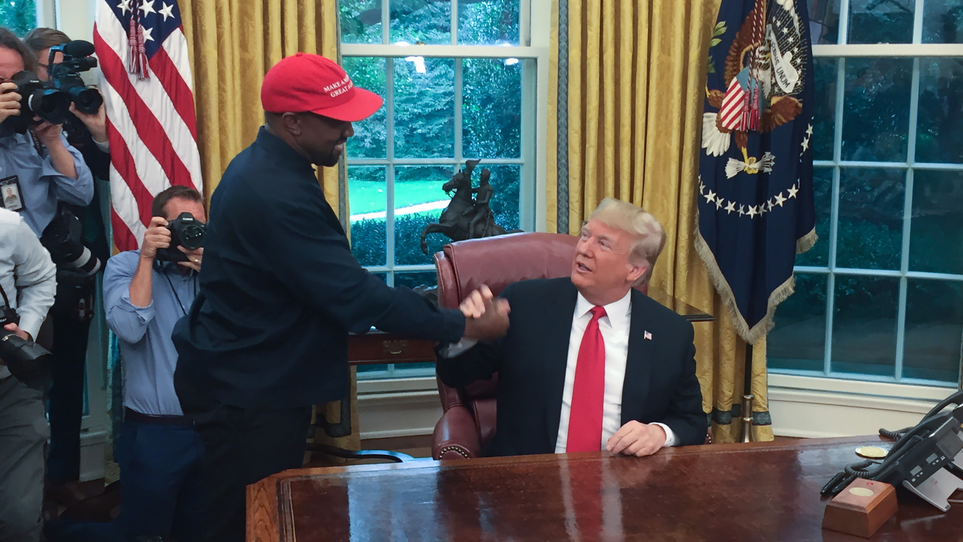 Kanye West gibt US-Präsident Donald Trump die Hand. | Bildquelle: AFP