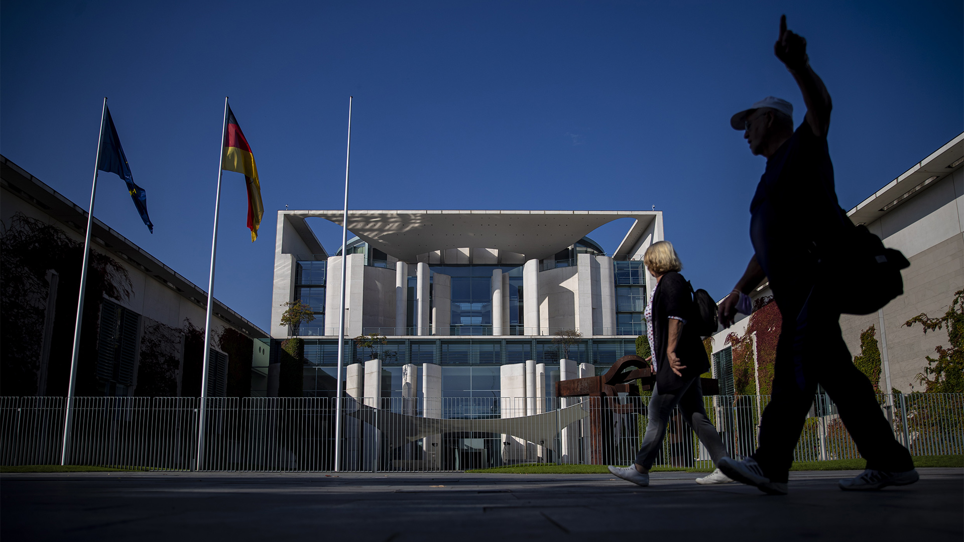 Menschen gehen am Kanzleramt in Berlin vorbei. | EPA