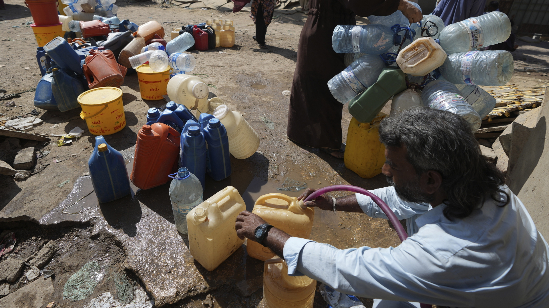 Menschen in Karatschi/Pakistan füllen Wasser in Kanister
