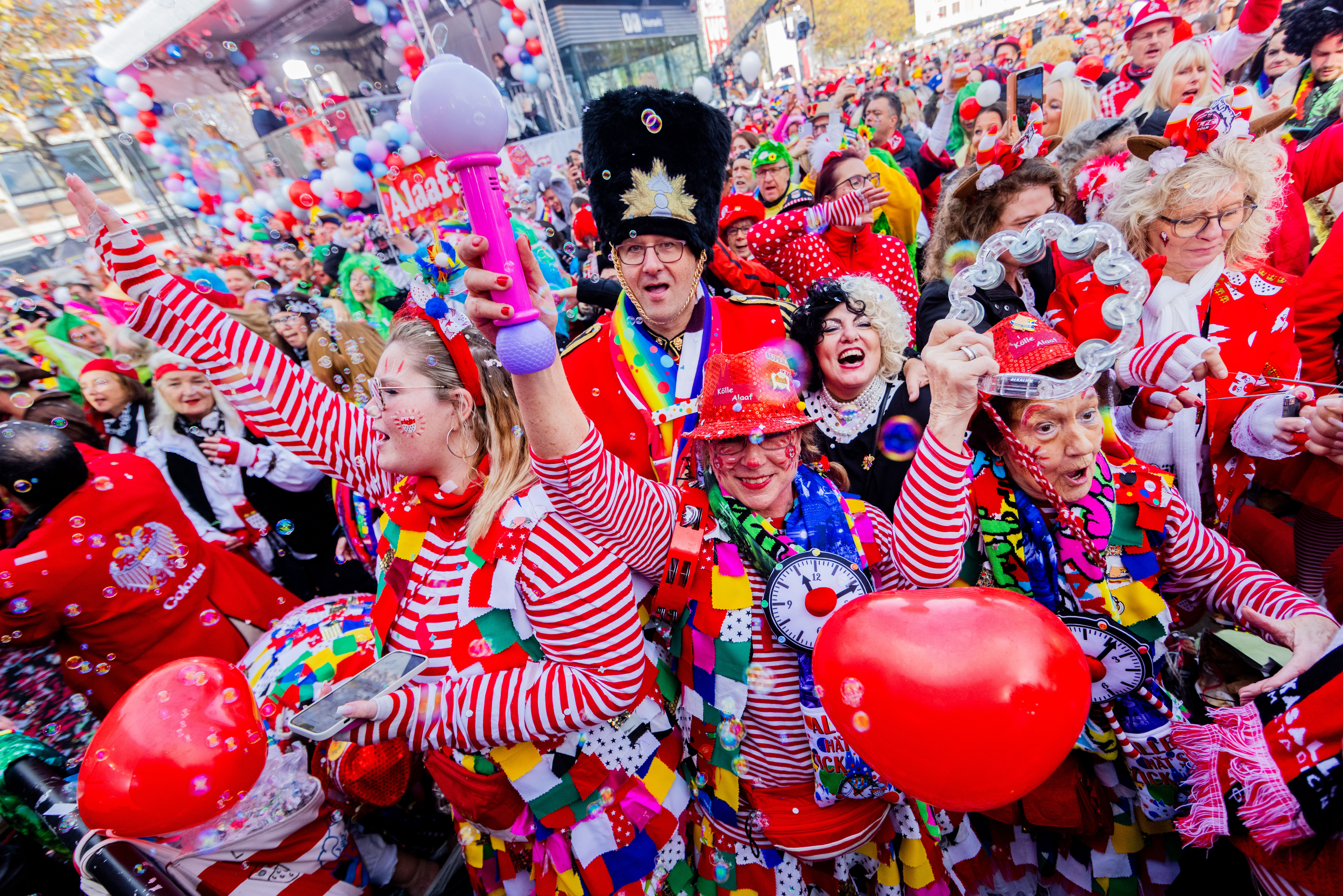 Eine vorwiegend rot kostümierte Menschengruppe begrüßt den Start des Karnevals | dpa