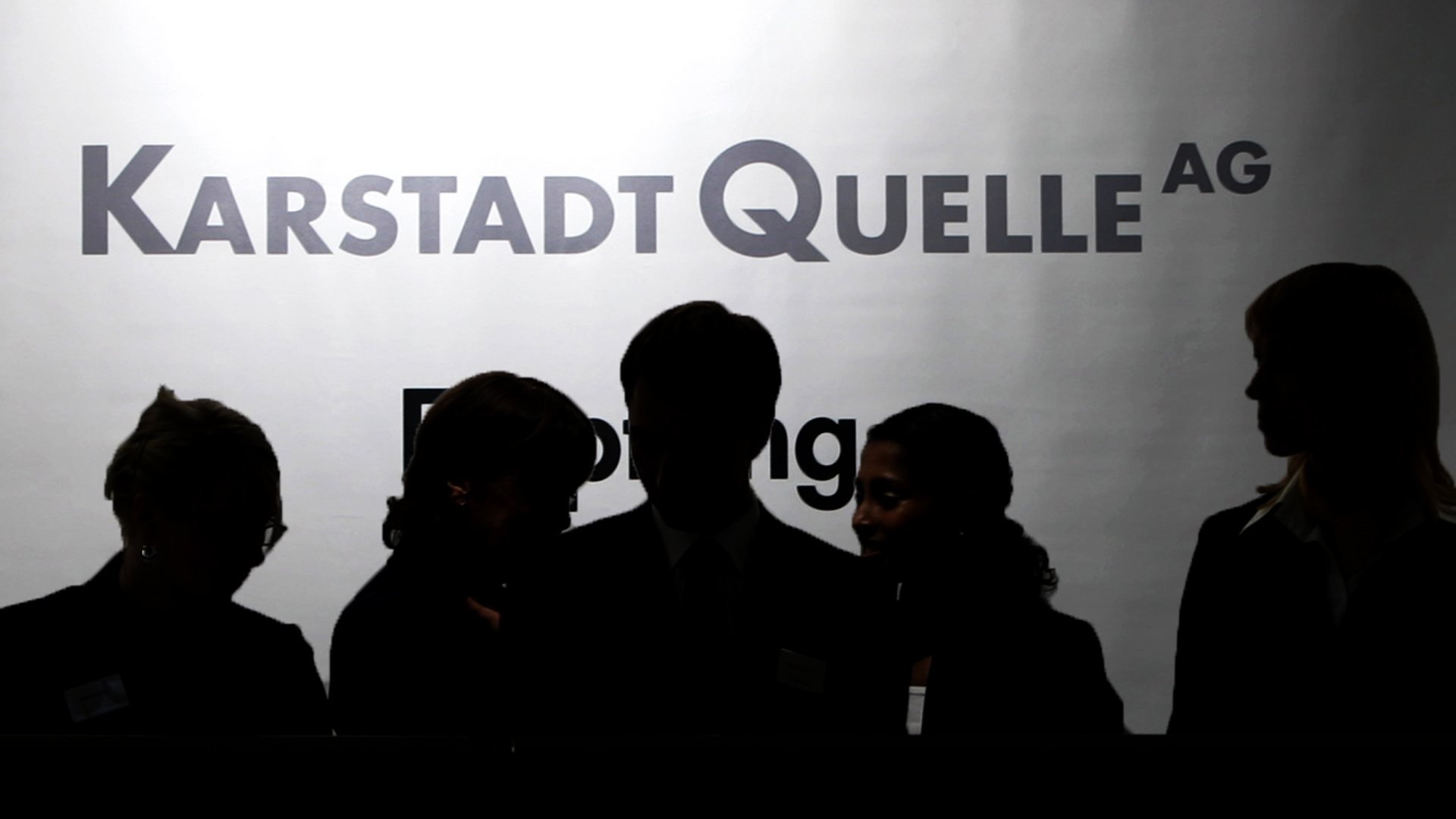 Silhouetten von Menschen vor einem Schriftzug der damaligen KarstadtQuelle AG | Bildquelle: picture-alliance/ dpa