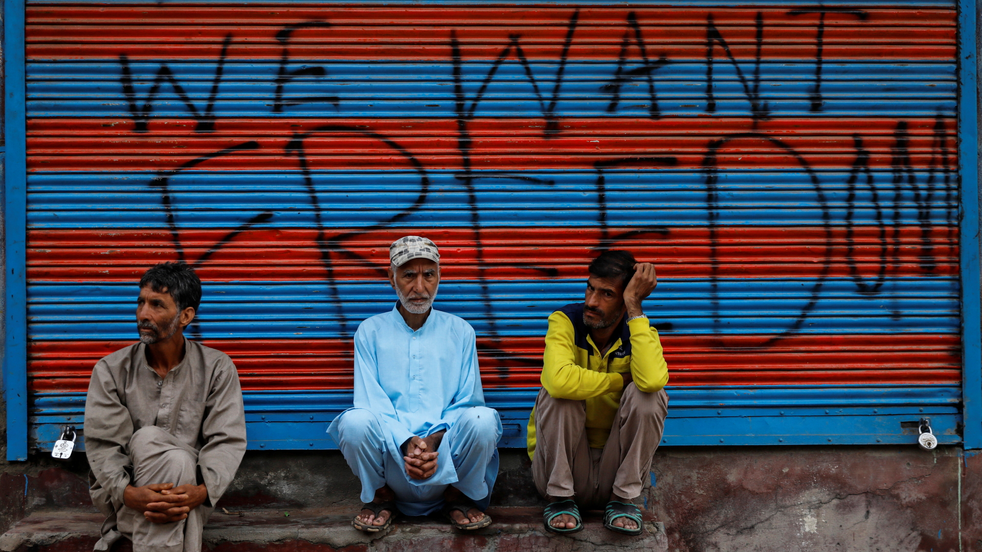 Männer sitzen auf Stufen in Srinagar | REUTERS