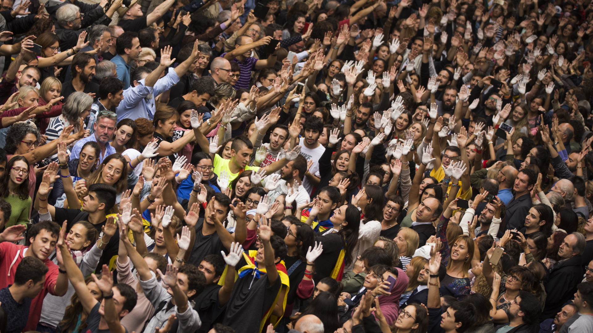 Unterstützer der katalanischen Unabhängigkeitsbewegung in Girona heben ihre Hände zum Zeichen des Protests. | AP