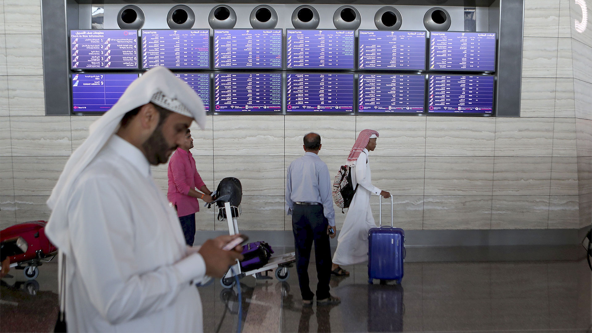Menschen stehen in einem Terminal am Flughafen von Katar